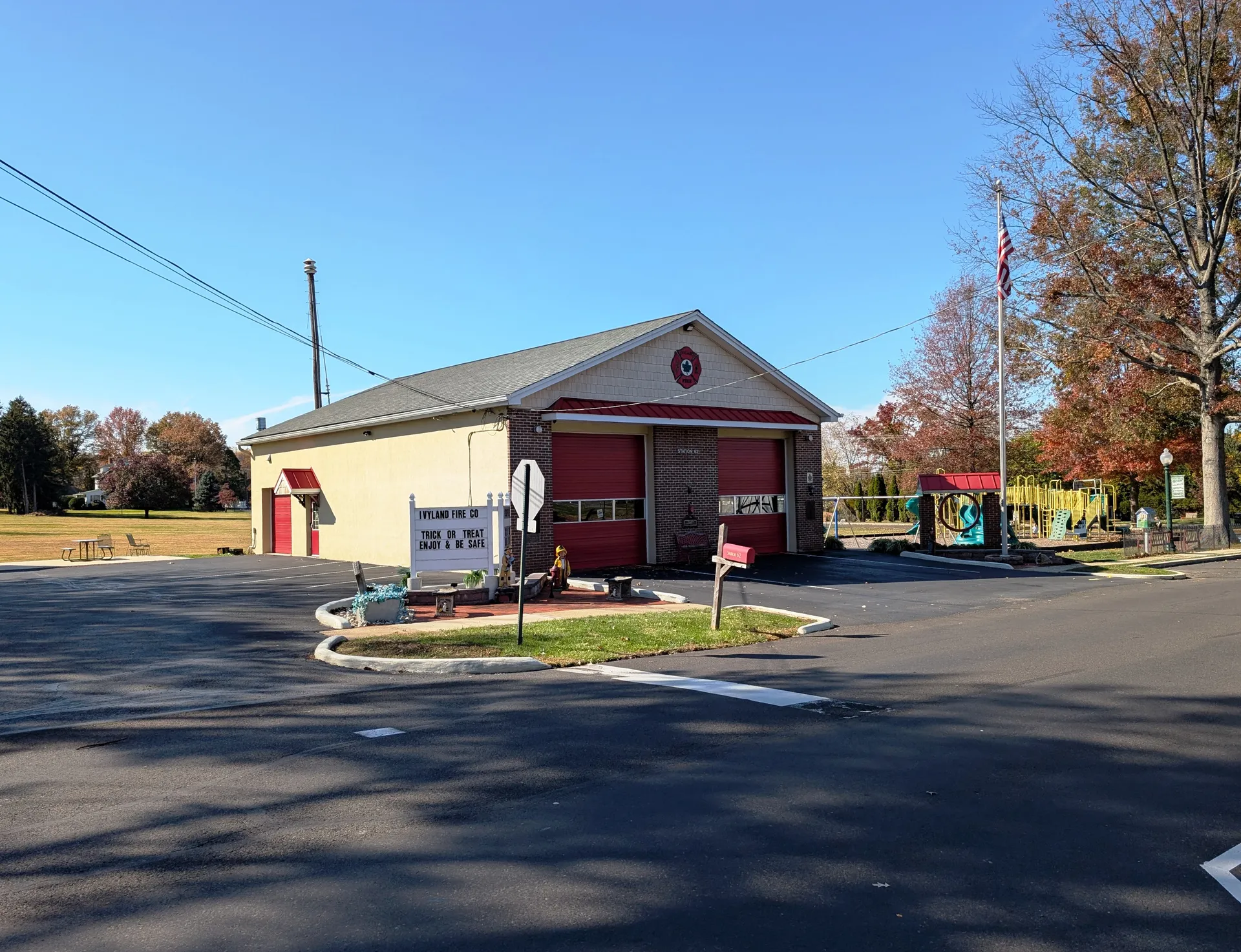 Ivyland Fire Company Station 46 is a brick firehouse with red bay doors on Dubois Avenue, with fall color behind it.