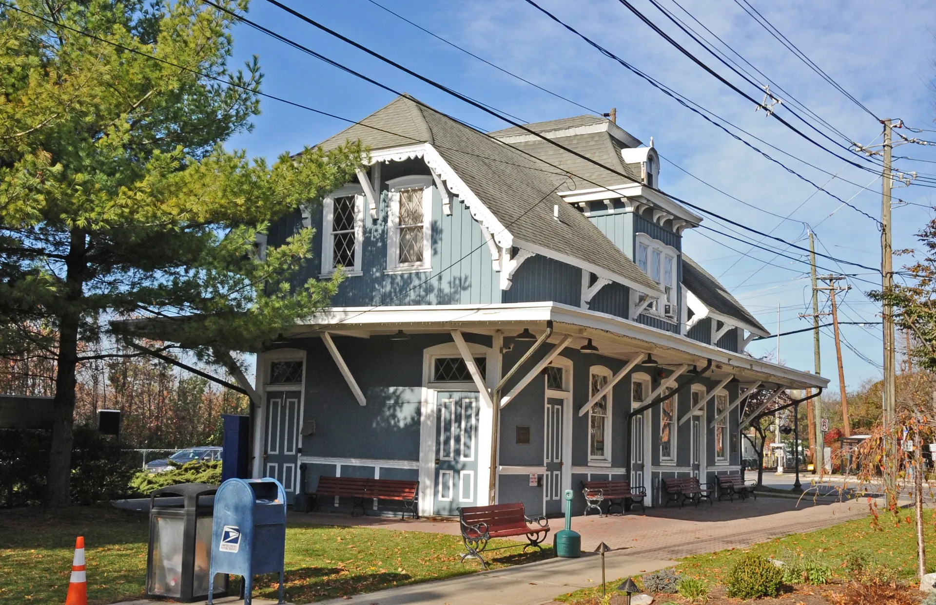Hillsdale Station is a blue-gray Victorian depot with a deep platform canopy and decorative trim along the tracks.