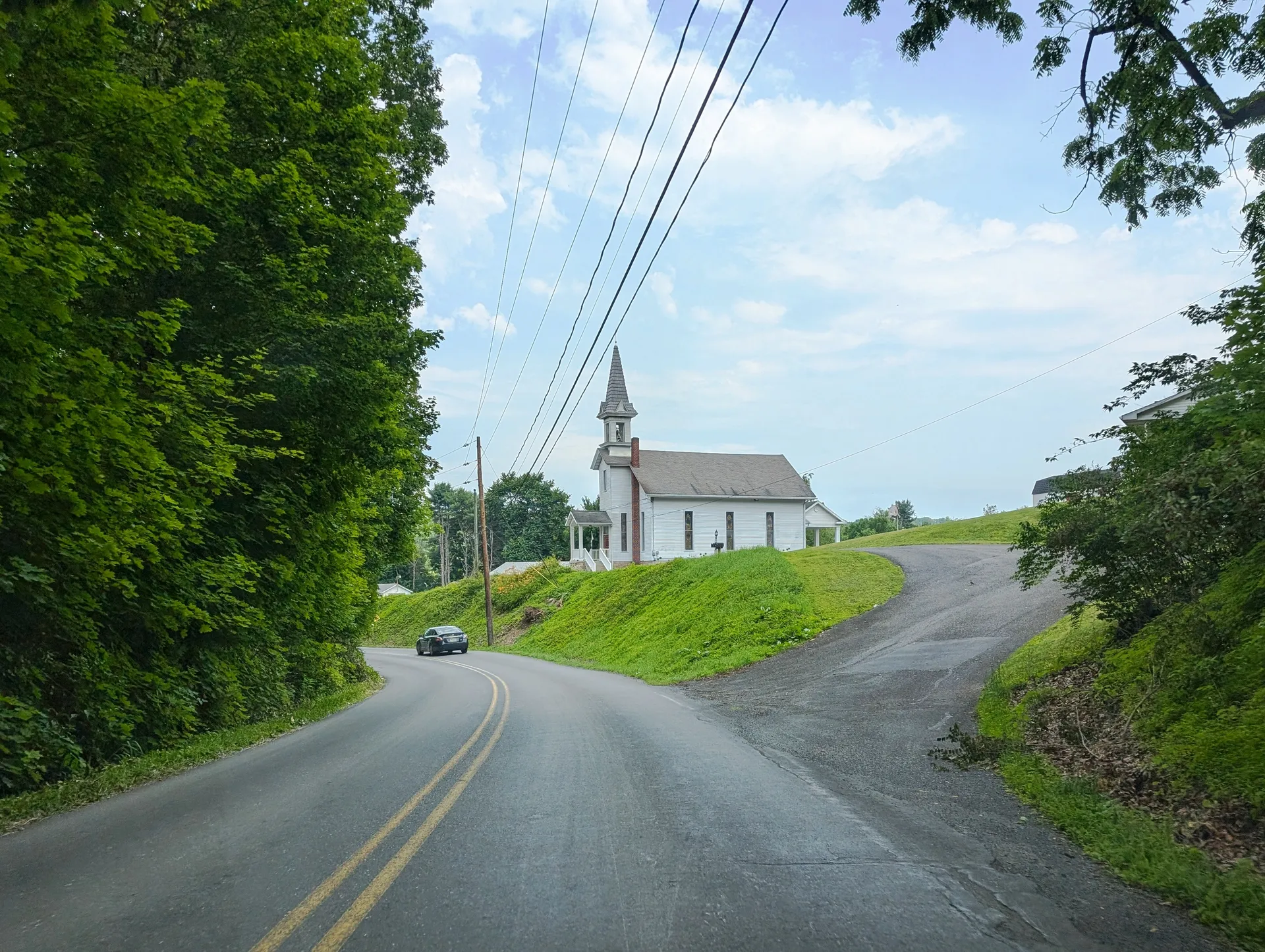 Main Street rises north through Klingerstown, with the white steeple of St. Michael's Lutheran Church on the hill ahead.