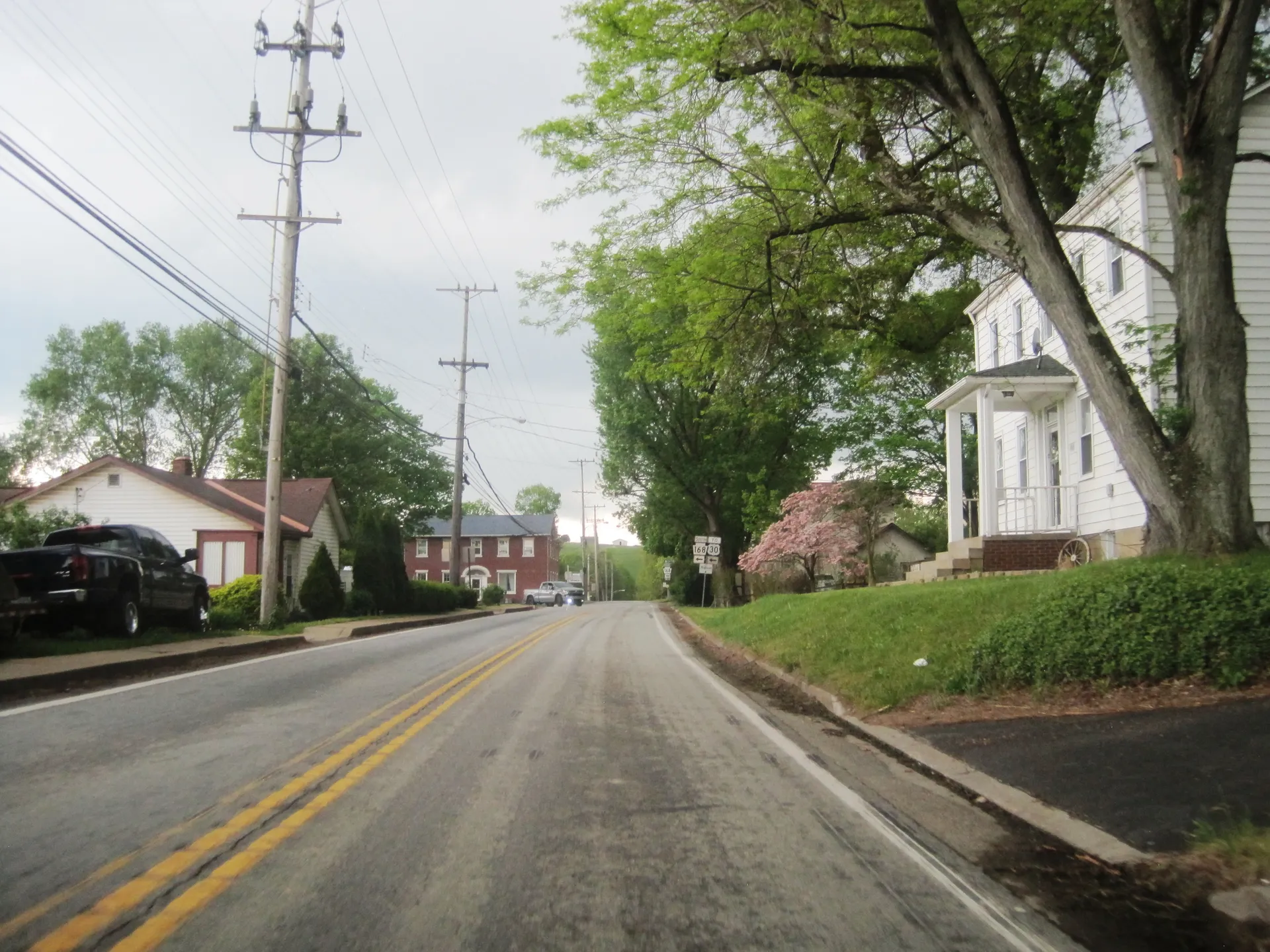 Pine Street (Route 168) curves west through Hookstown between Mill and Main streets past an old house and yard.