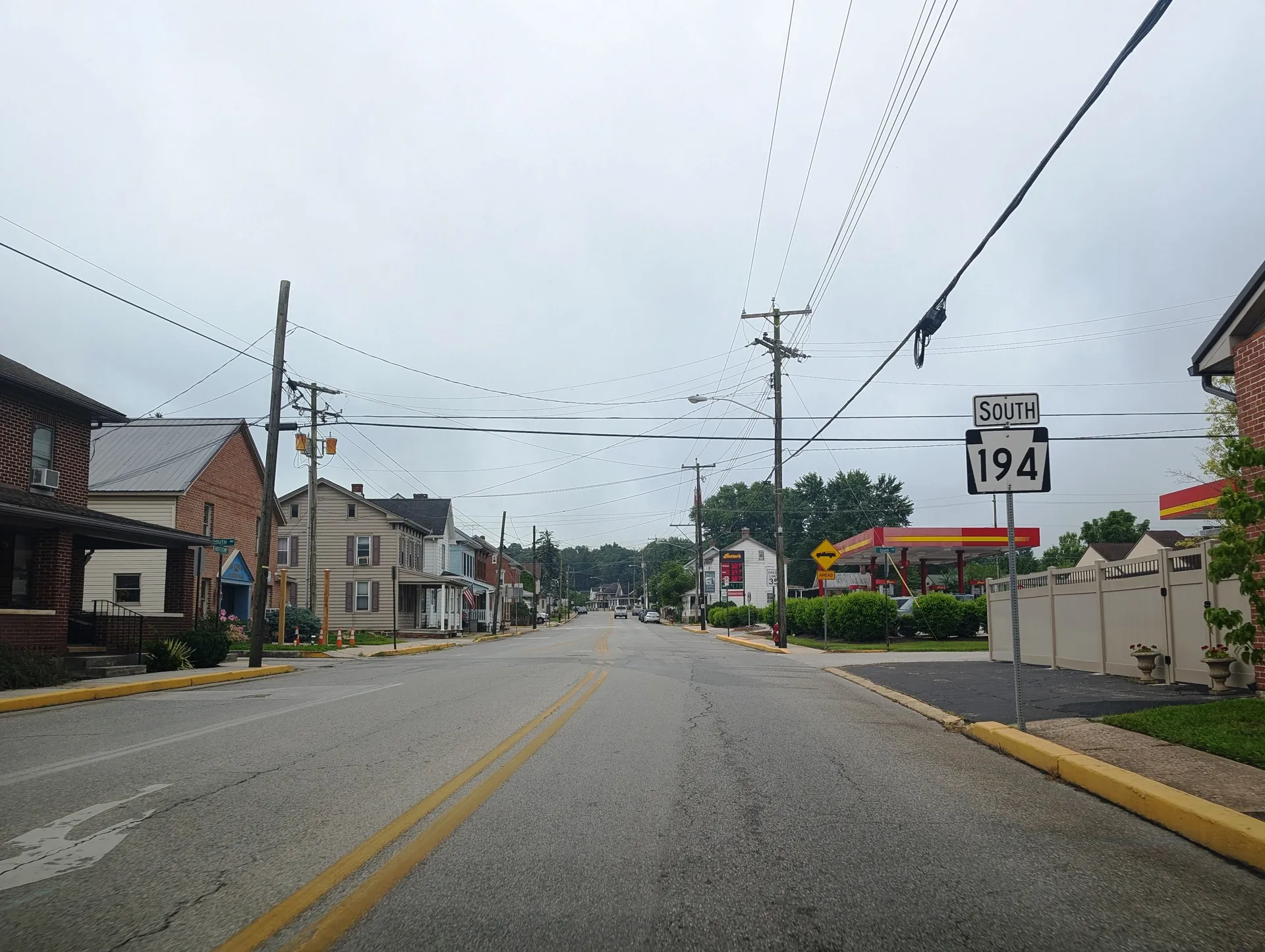 Abbottstown Street (Route 194) runs south through East Berlin past brick rowhouses and storefronts on an overcast day.
