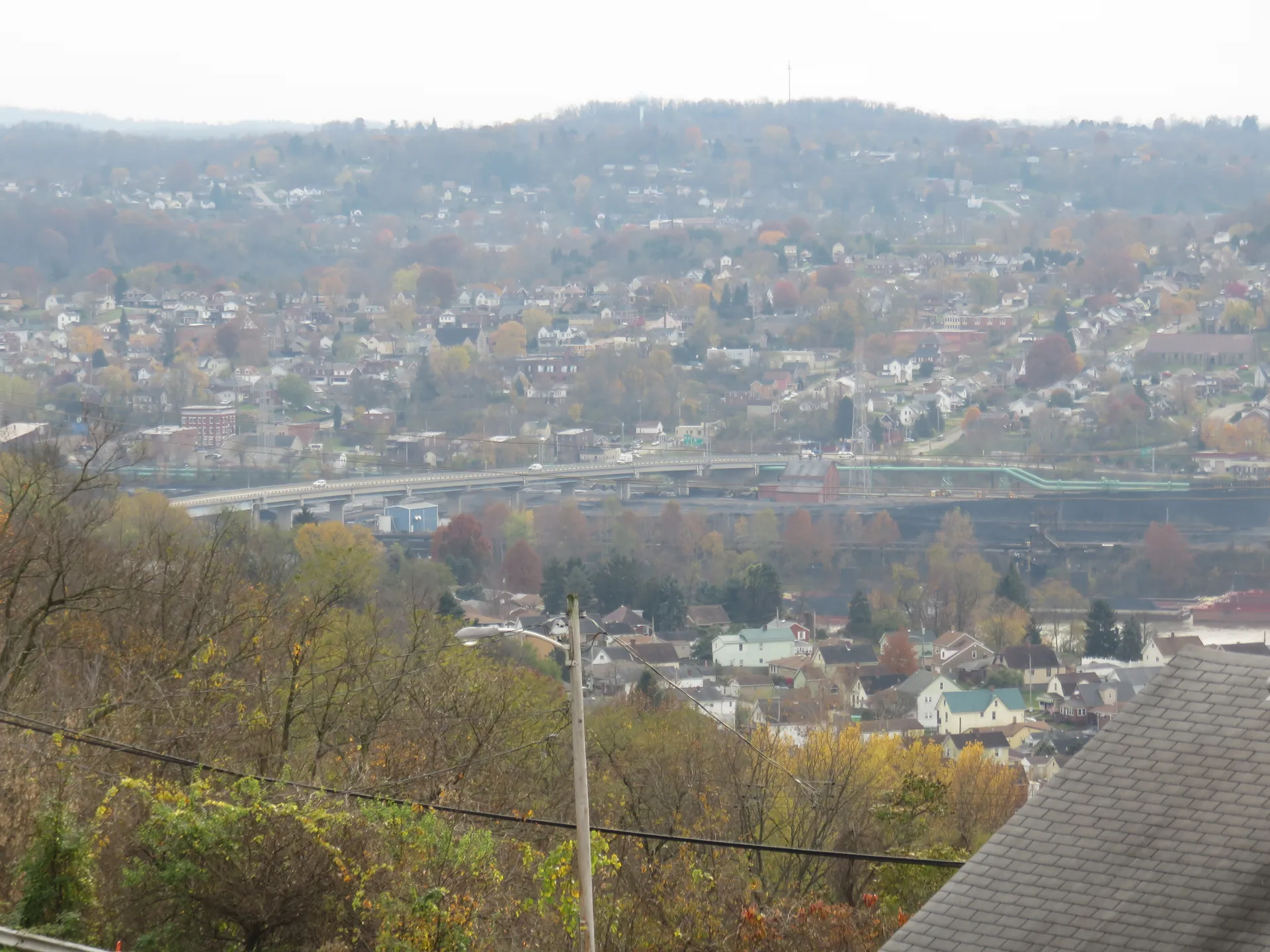 Houses climb the steep hillsides of Clairton above the Monongahela valley, with the Clairton-Glassport Bridge visible below.