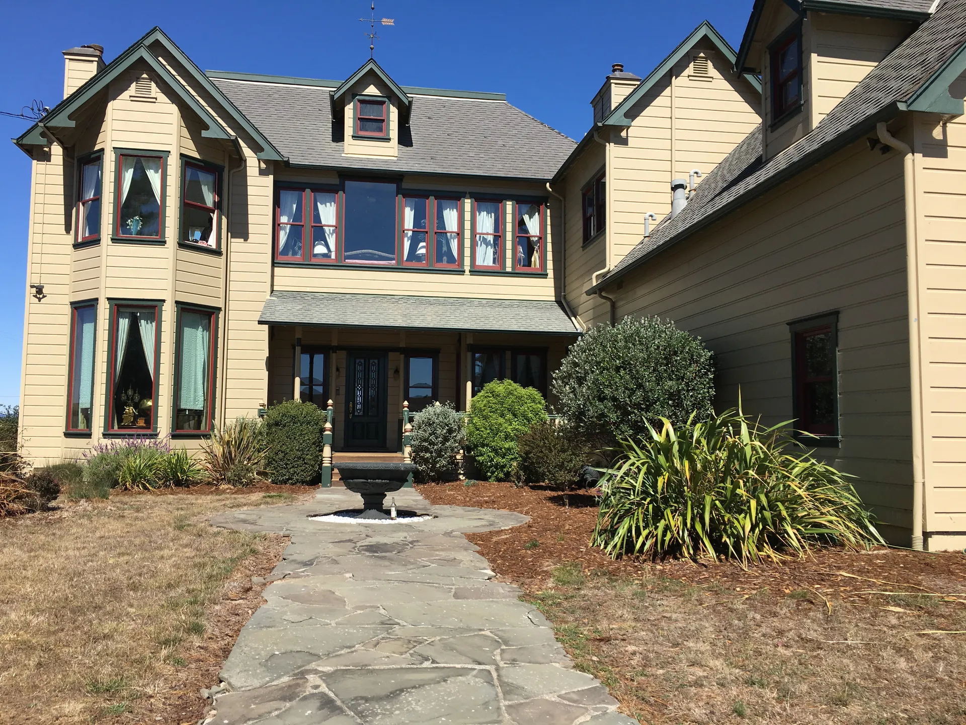 Historic two-story house with a garden walkway in Tomales, California.