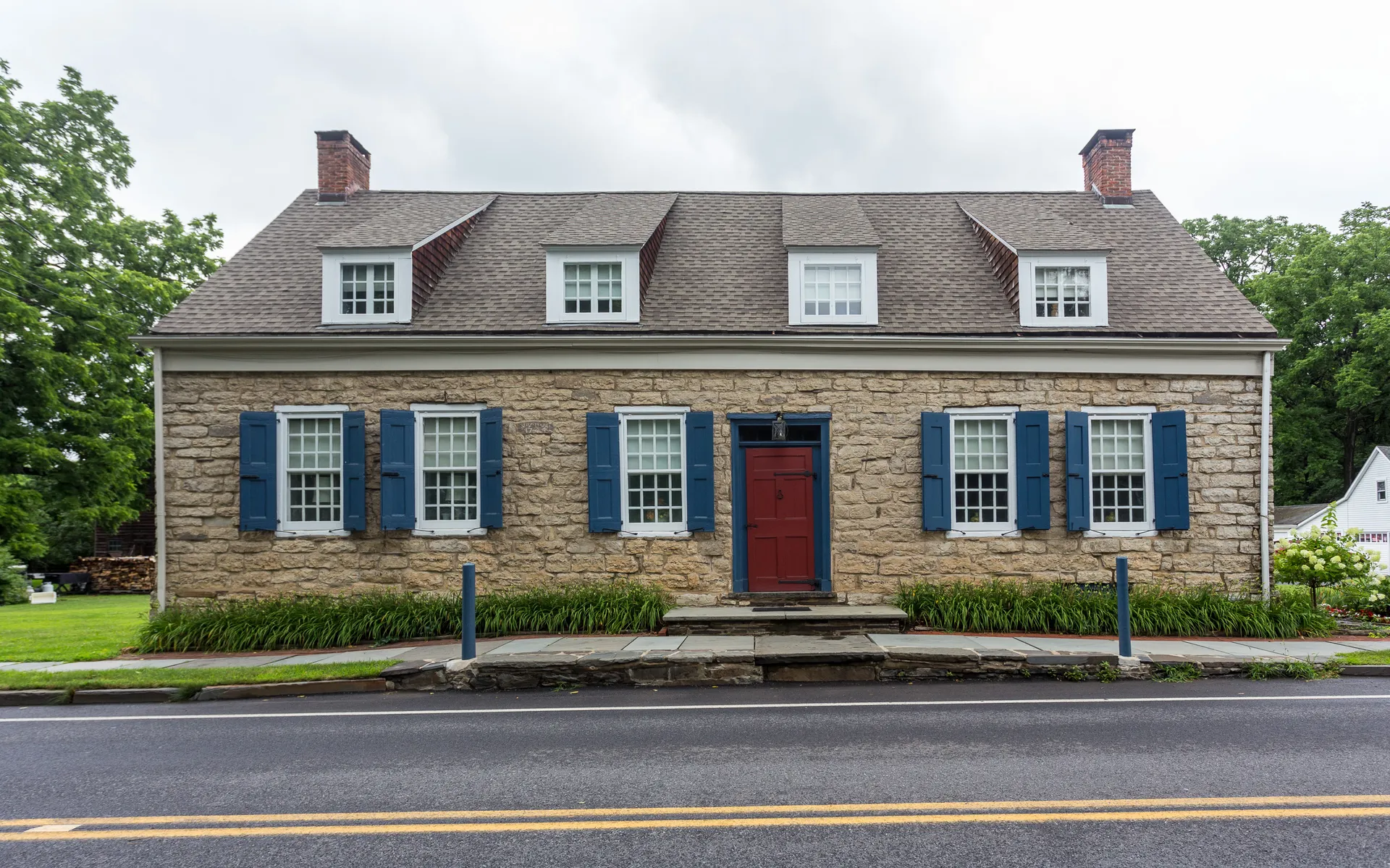 Historic stone Van Deusen House with red door in Hurley, New York.