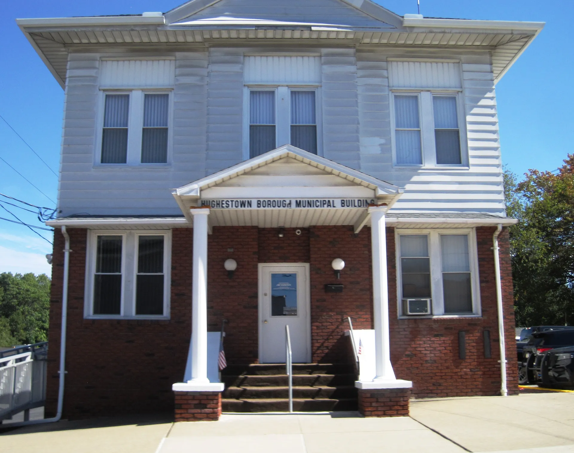 Hughestown's municipal building is a two-story brick building with a white columned portico on Center Street.