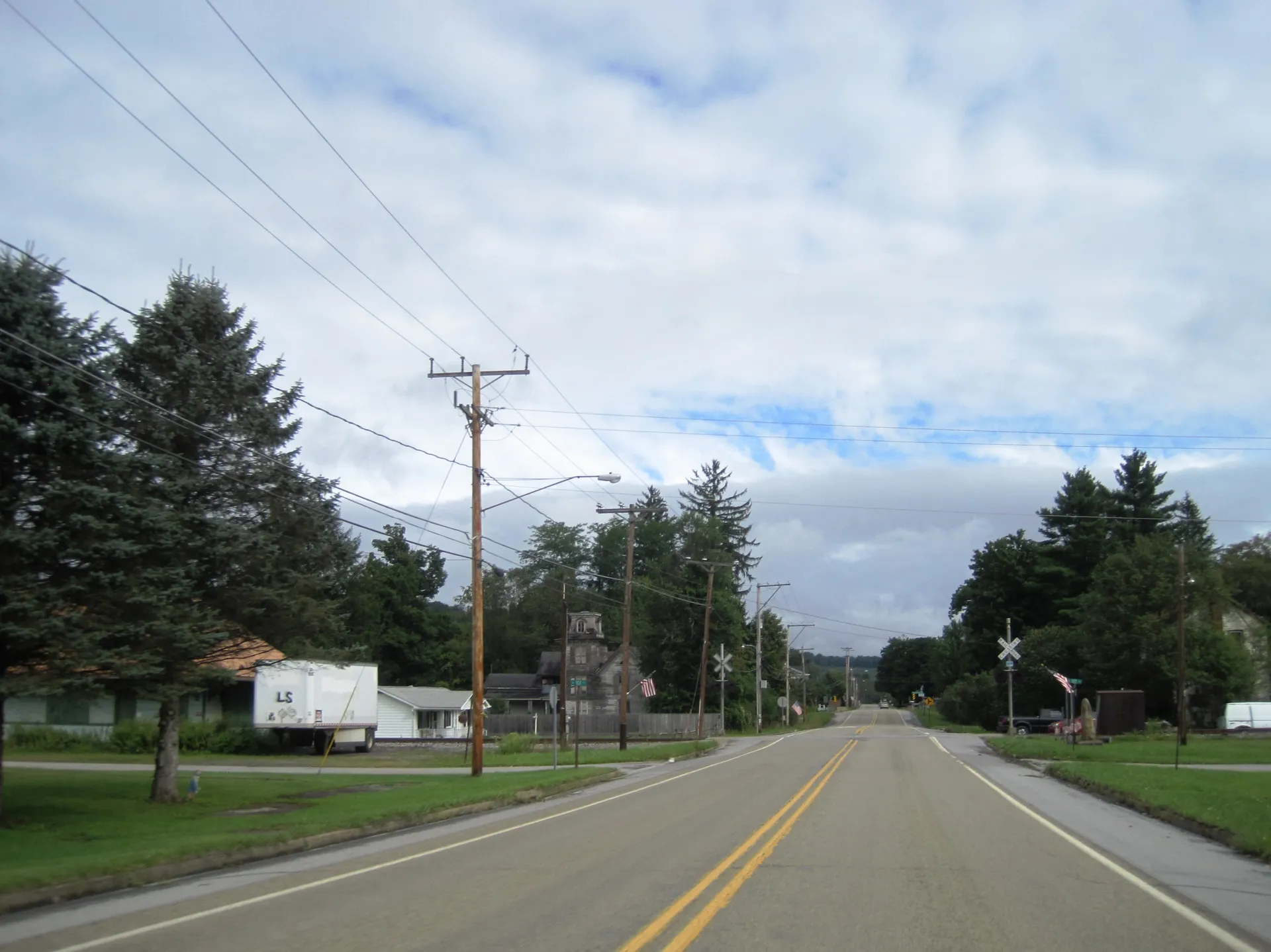 Main Street (U.S. Route 219) in Burnside borough heads north between 1st and 2nd streets, with homes and a church beside the road.