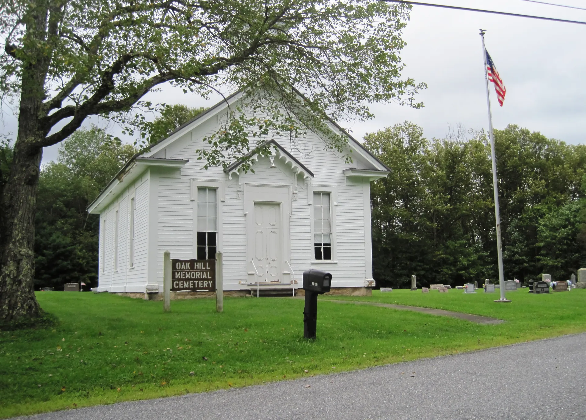 A small white chapel with a flag stands at the edge of Oak Hill Memorial Cemetery in Karthaus Township, Clearfield County.