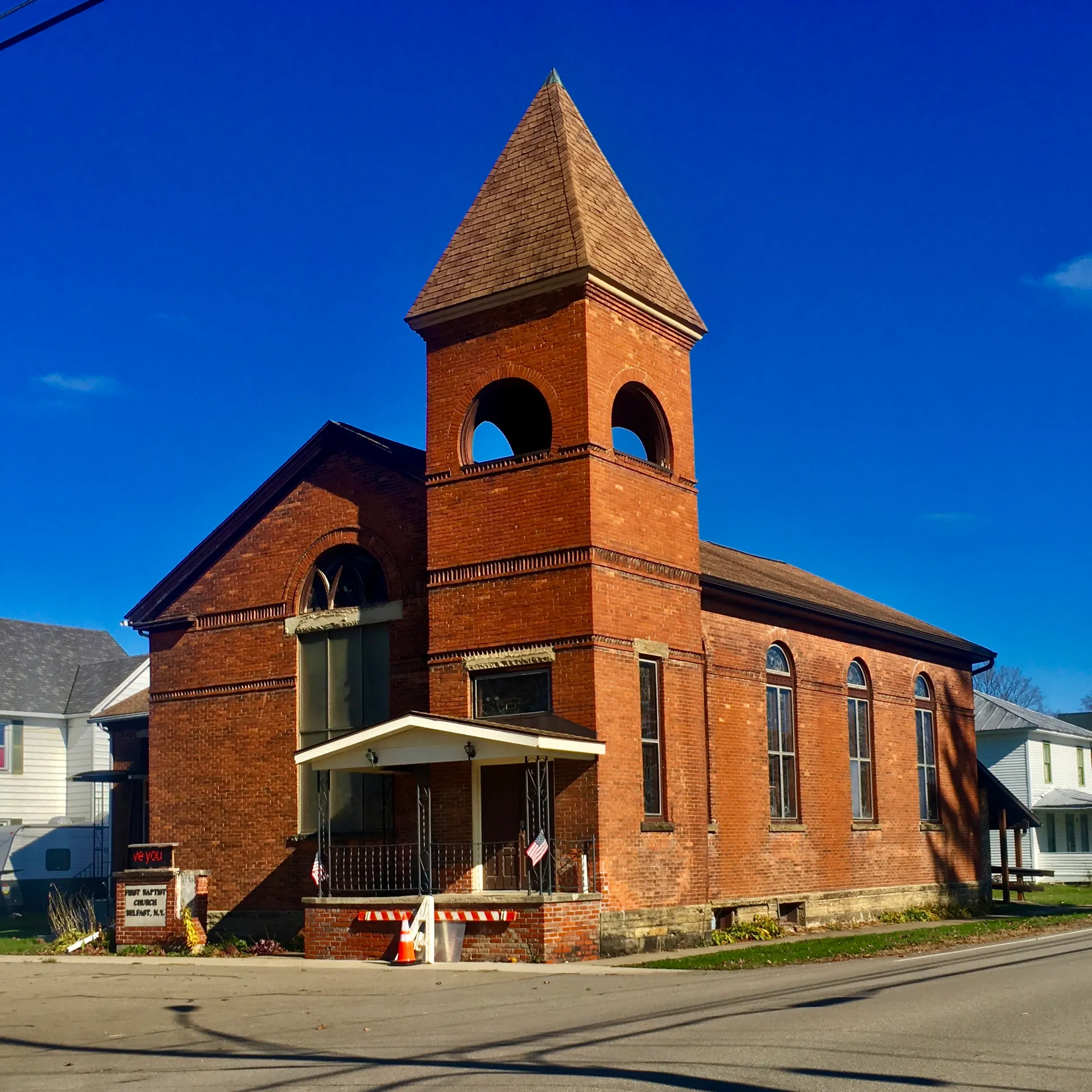 Historic brick First Baptist Church with a bell tower in Belfast, New York.