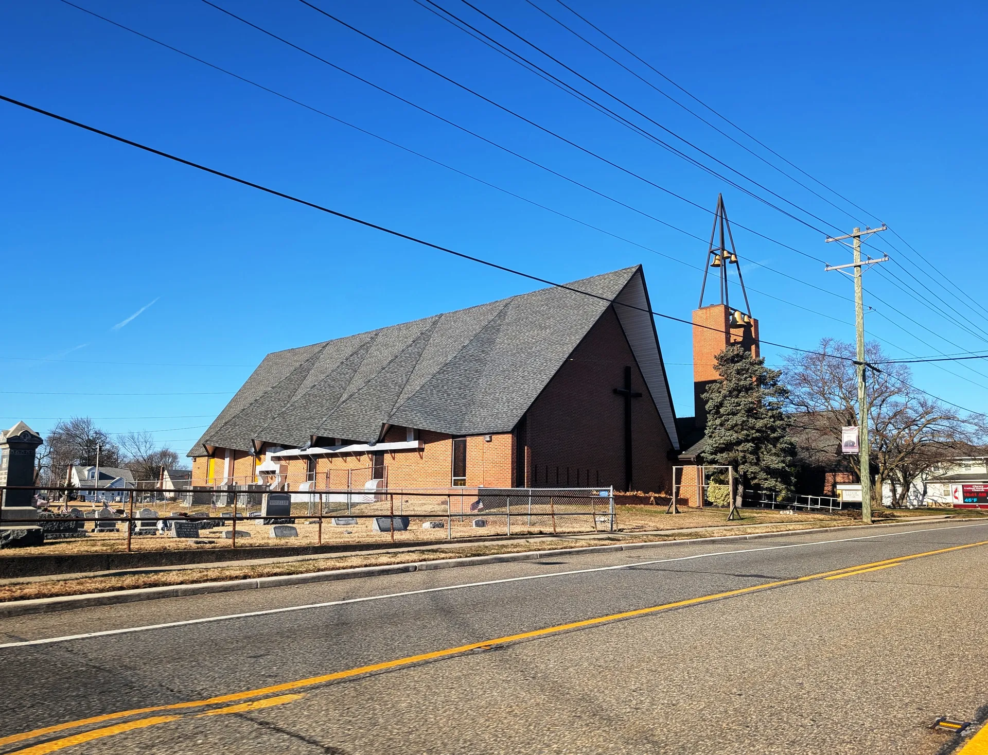 Chews United Methodist Church in Glendora has a steep dark roof and a brick facade topped by a small spire.