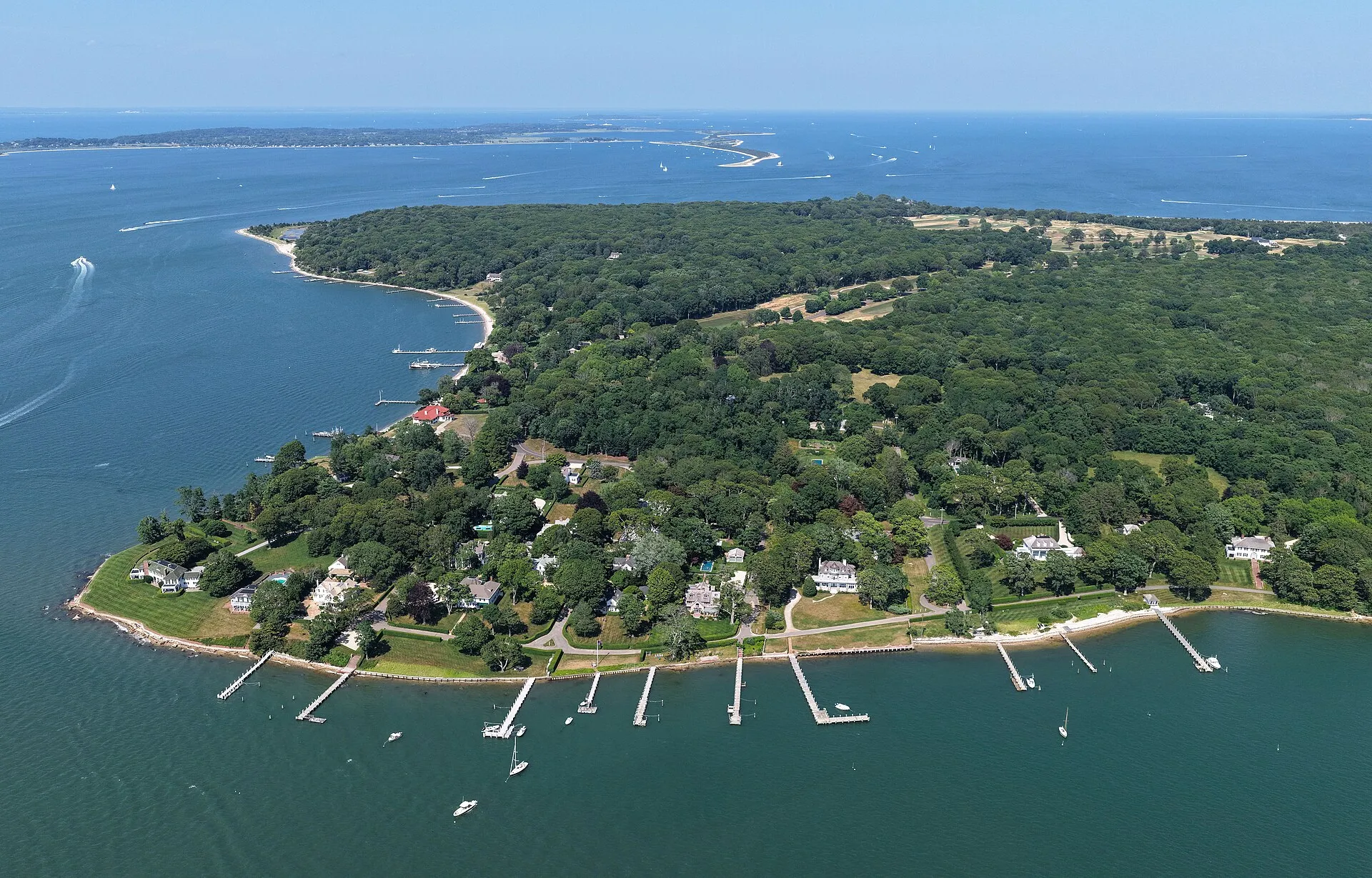 Aerial view of the shoreline and wooded estates of Dering Harbor, New York.