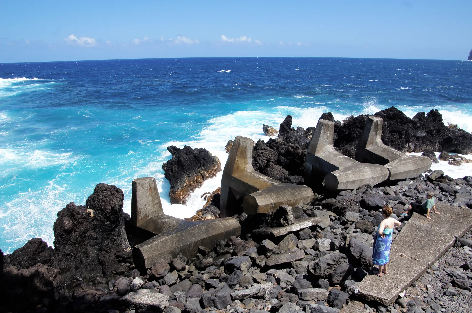 Concrete breakwater blocks and blue surf at Laupahoehoe Point, Big Island, Hawaii.