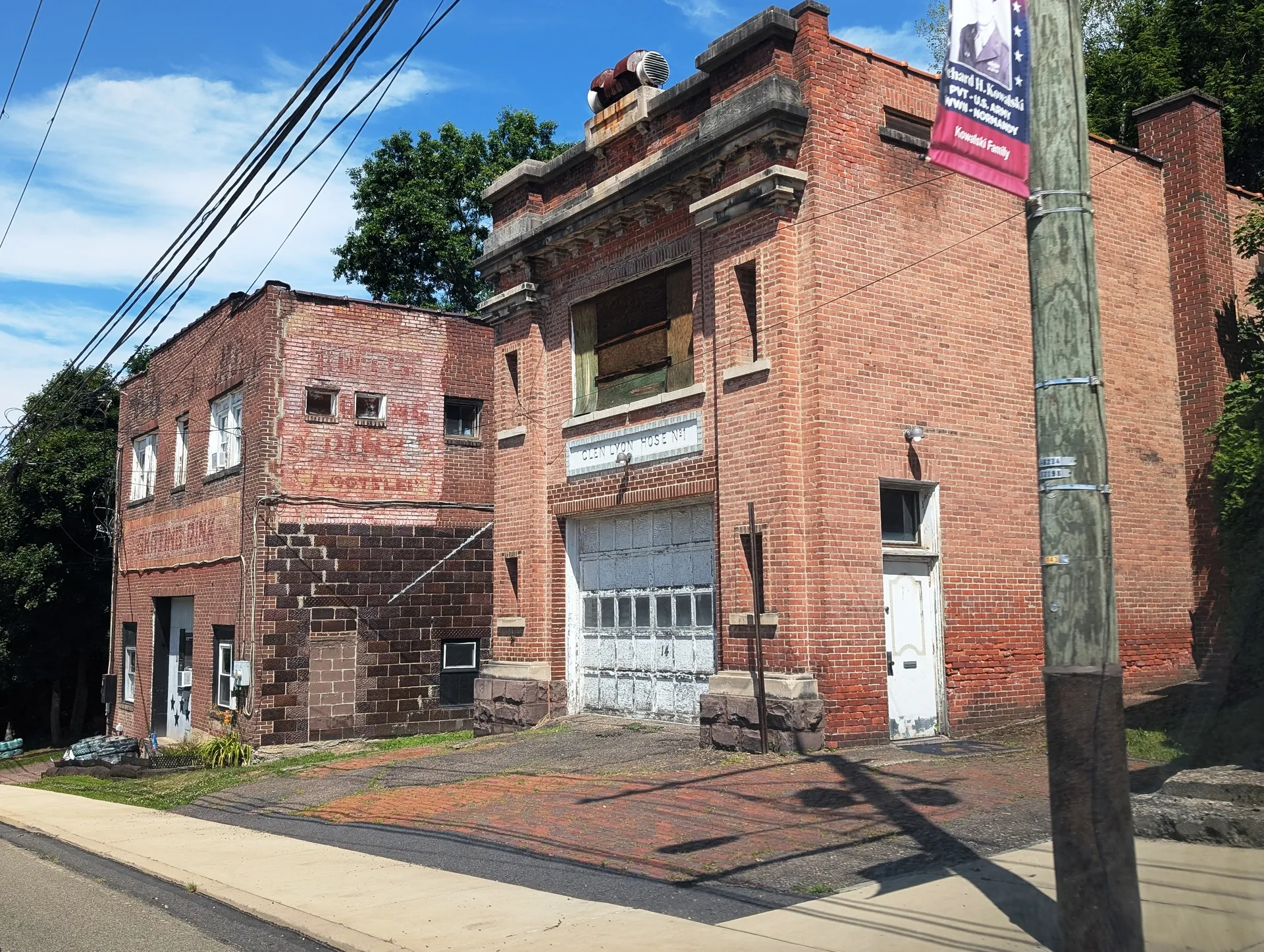 The former Glen Lyon Hose Company No. 1 building is a brick structure with a tall decorative facade on East Main Street.