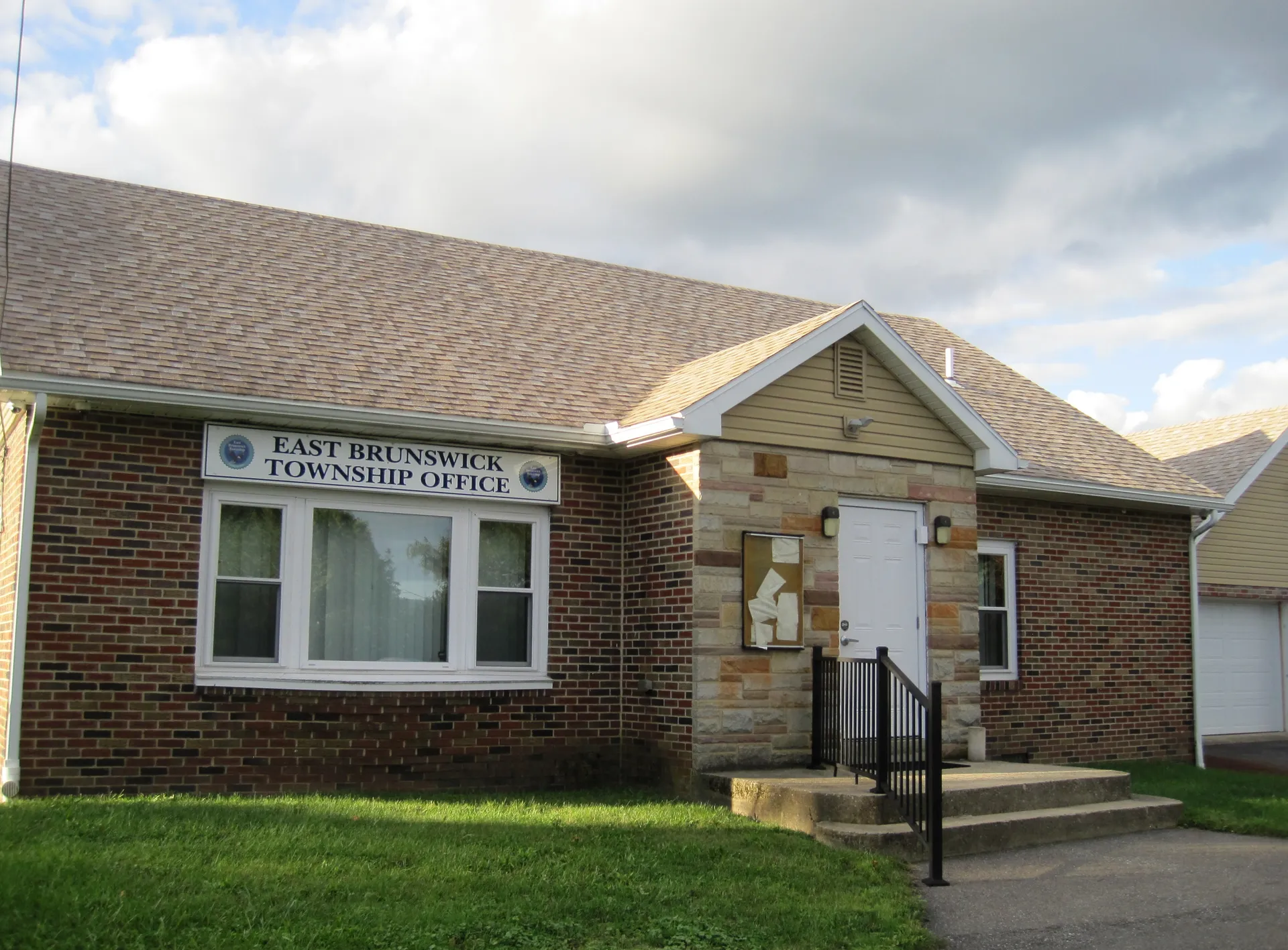 East Brunswick Township's municipal building in McKeansburg is a brick and tan-sided structure with a sign above the entry.