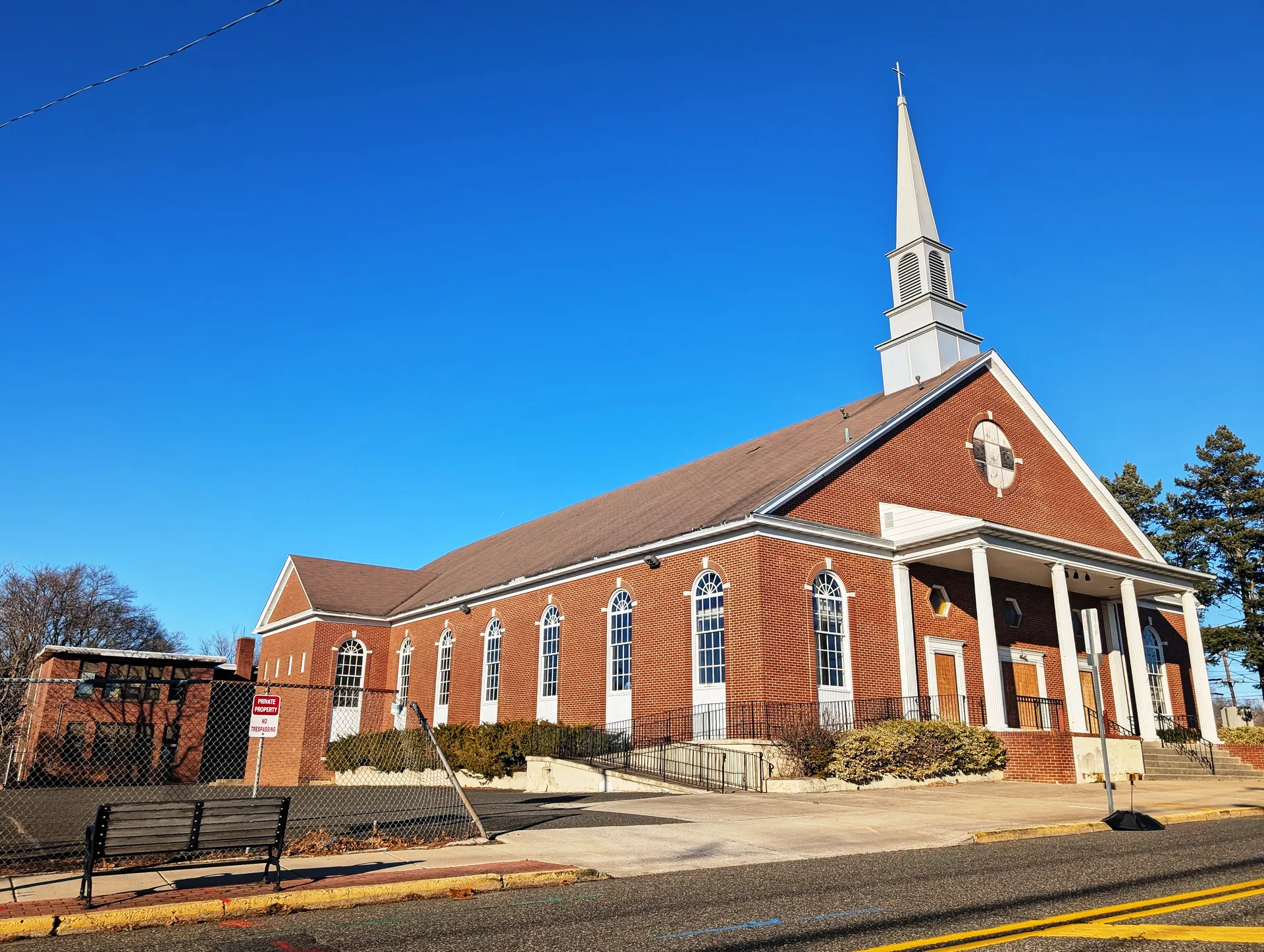 The former Emmaus Catholic Community Church in Mount Ephraim is a red brick church with a tall white spire.