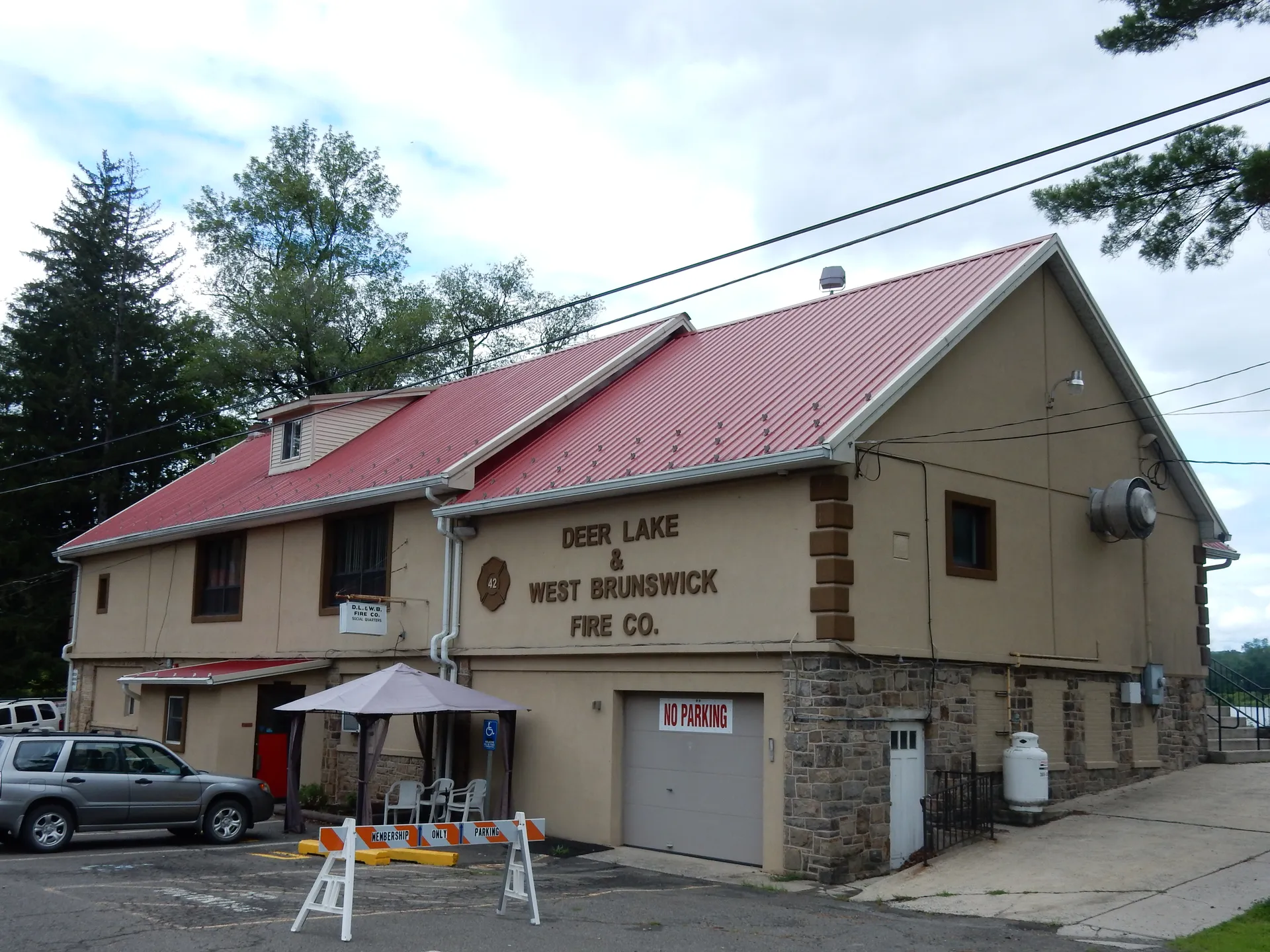 The Deer Lake and West Brunswick Fire Company occupies a building with a red metal roof and garage bay in Deer Lake.