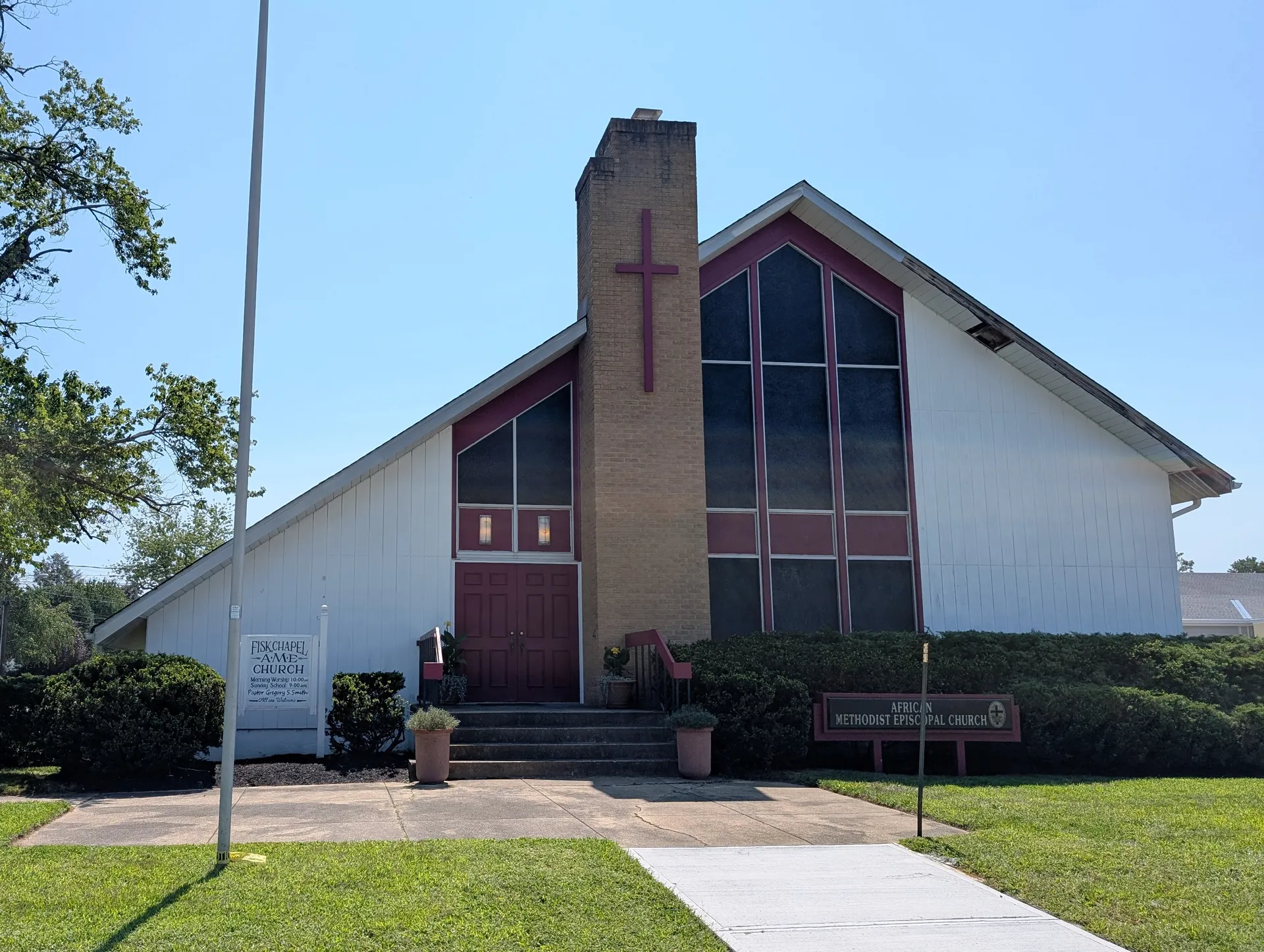 Fisk Chapel AME Church in Fair Haven has a tall brick chimney-like tower with a cross and large red-framed windows.