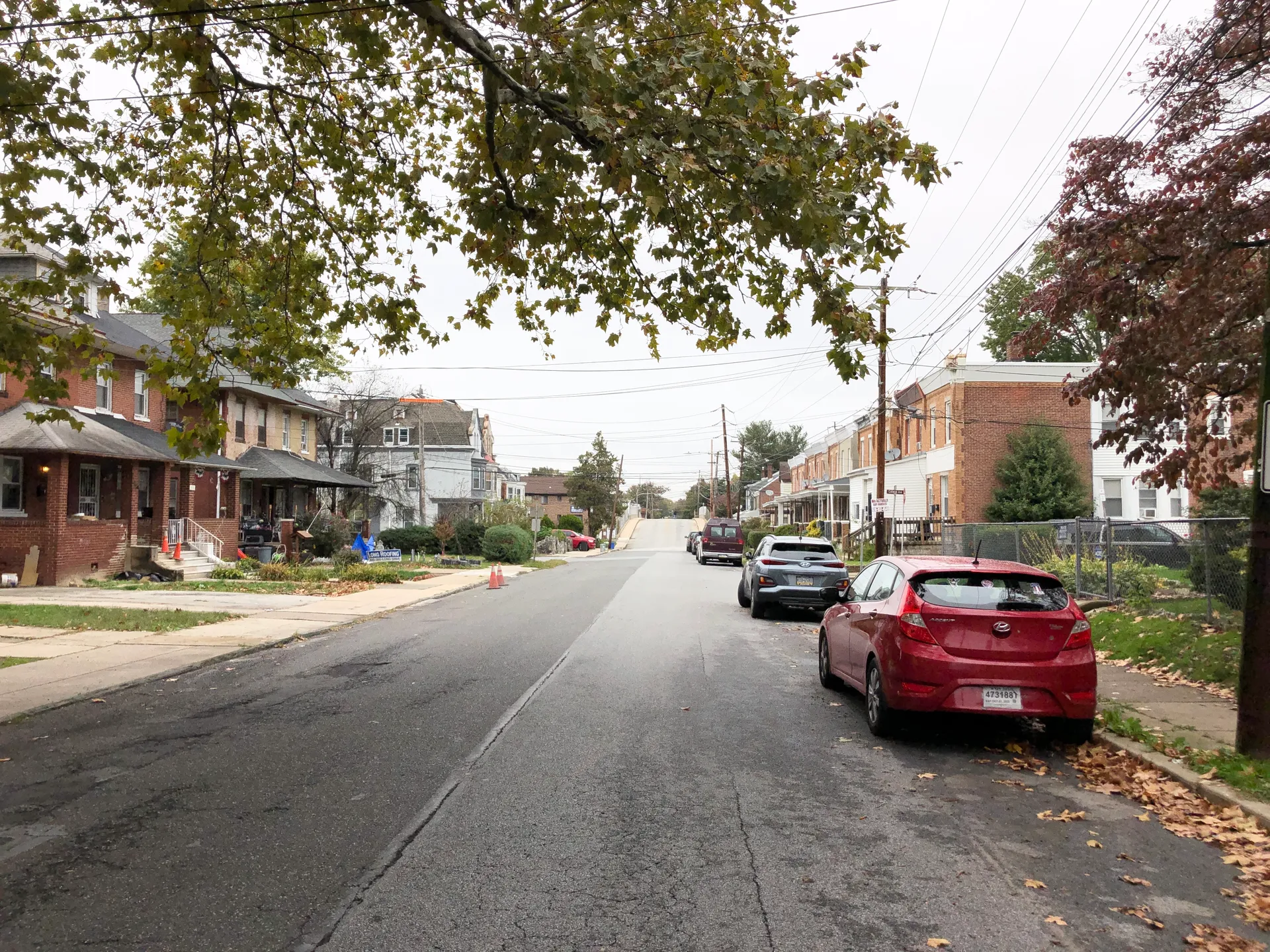 South Fourth Street in Colwyn runs north at Thatcher Avenue, lined with brick rowhouses, parked cars and leafy trees.