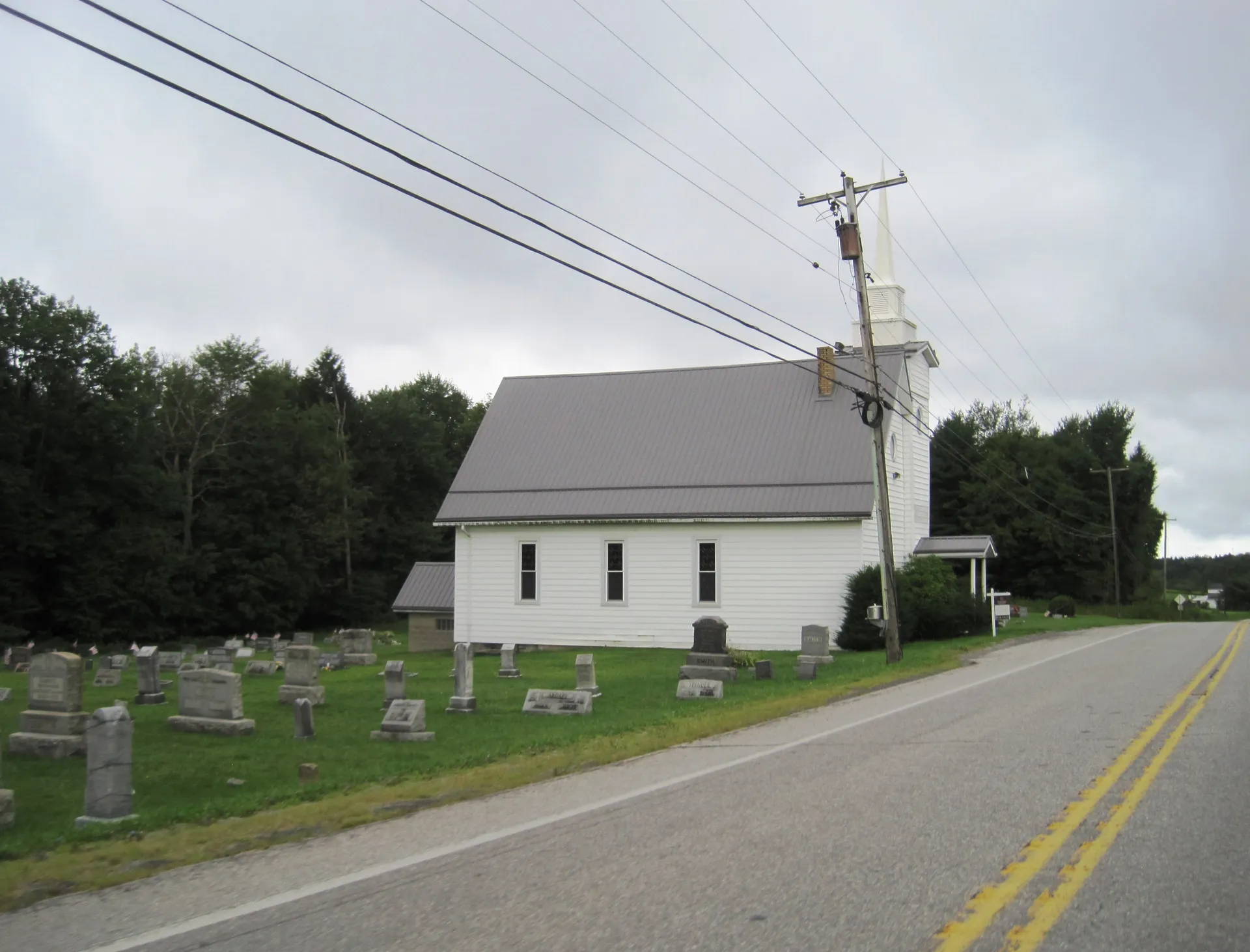 Chestnut Grove United Methodist Church, a white frame chapel with a small steeple, stands beside its cemetery along U.S. Route 219 in Bloom Township.