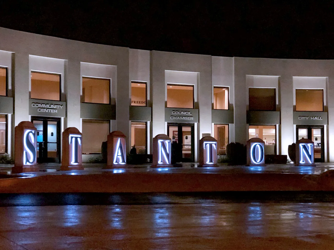 Stanton, CA — Stanton City Hall at night with illuminated letters and reflections.