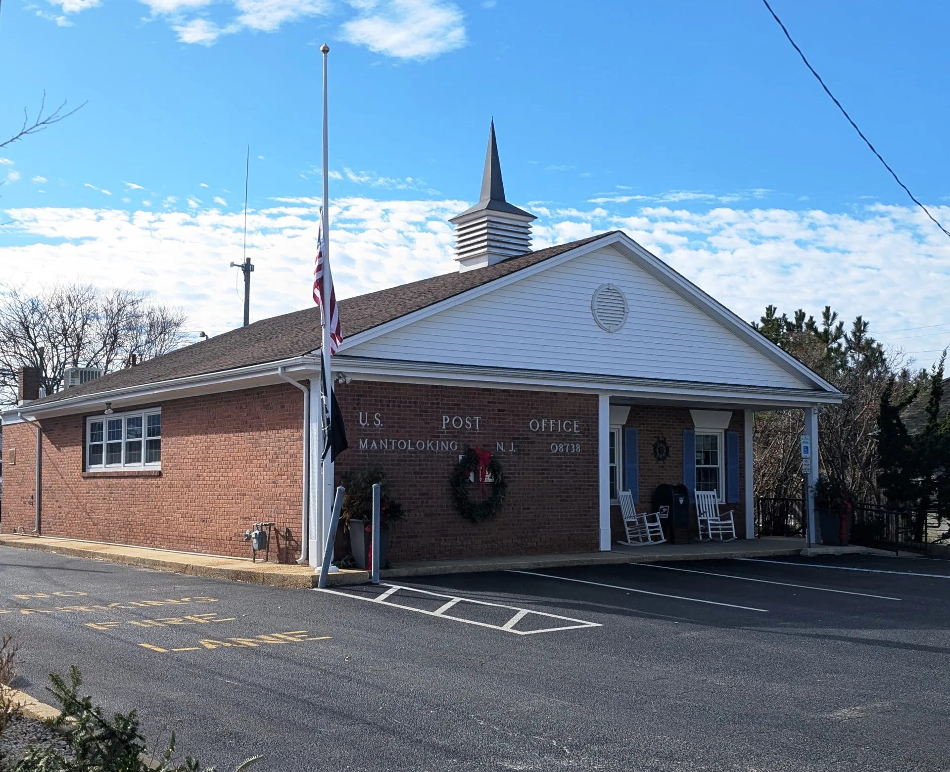 Mantoloking's post office is a small brick building with a white gable, a cupola and a holiday wreath above the door.