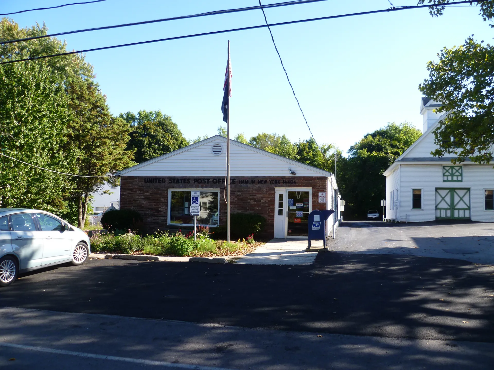 Small post office building with a flag in Hamlin, New York.