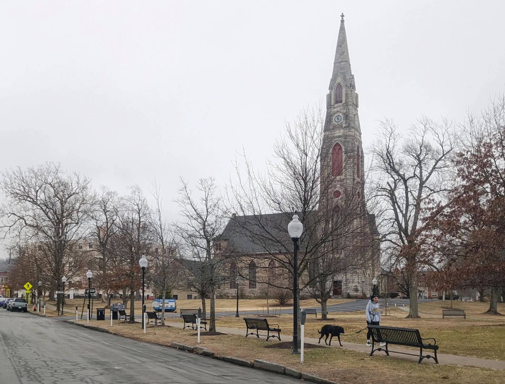 Church spire rising above a tree-lined park in Goshen, New York.