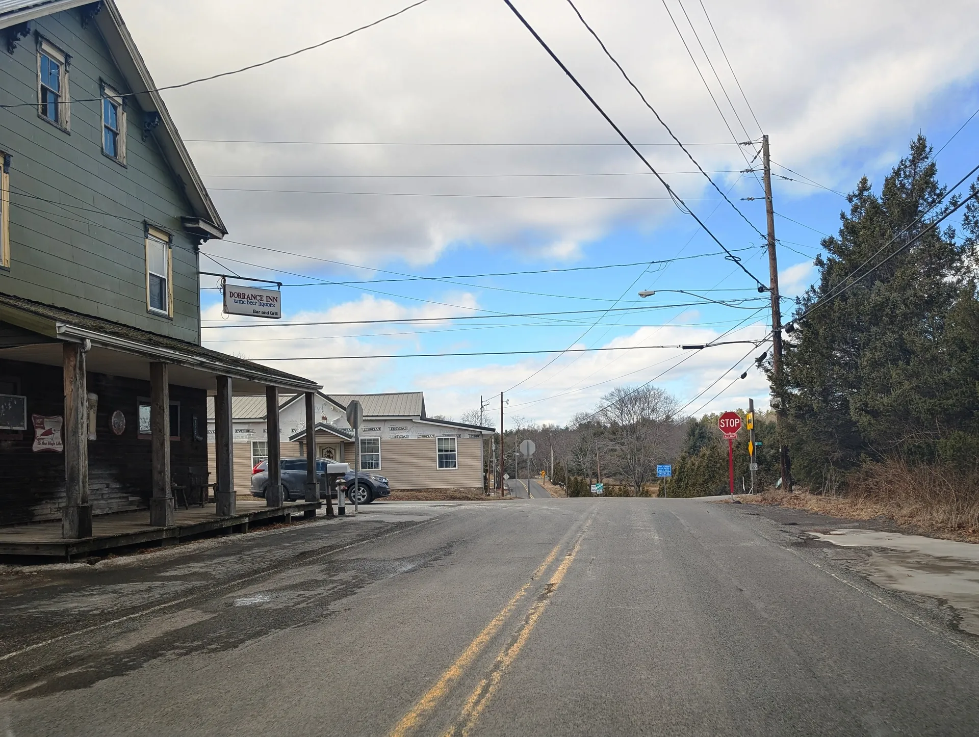 Blue Ridge Trail runs through the village of Dorrance at St. Marys Road, with a covered porch building and houses on the left.