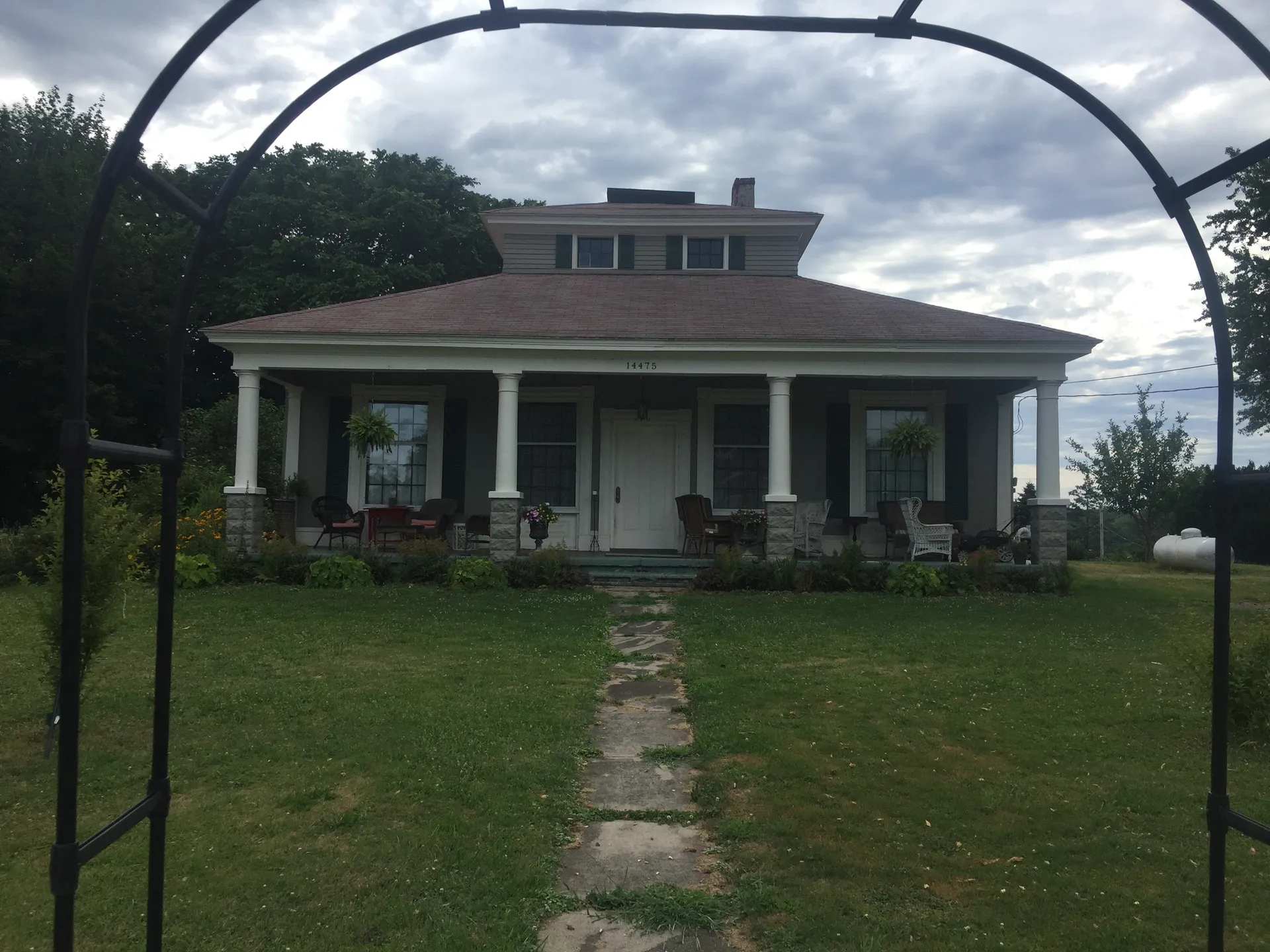 Historic Cottage Farm house with a front porch in Fair Haven, New York.