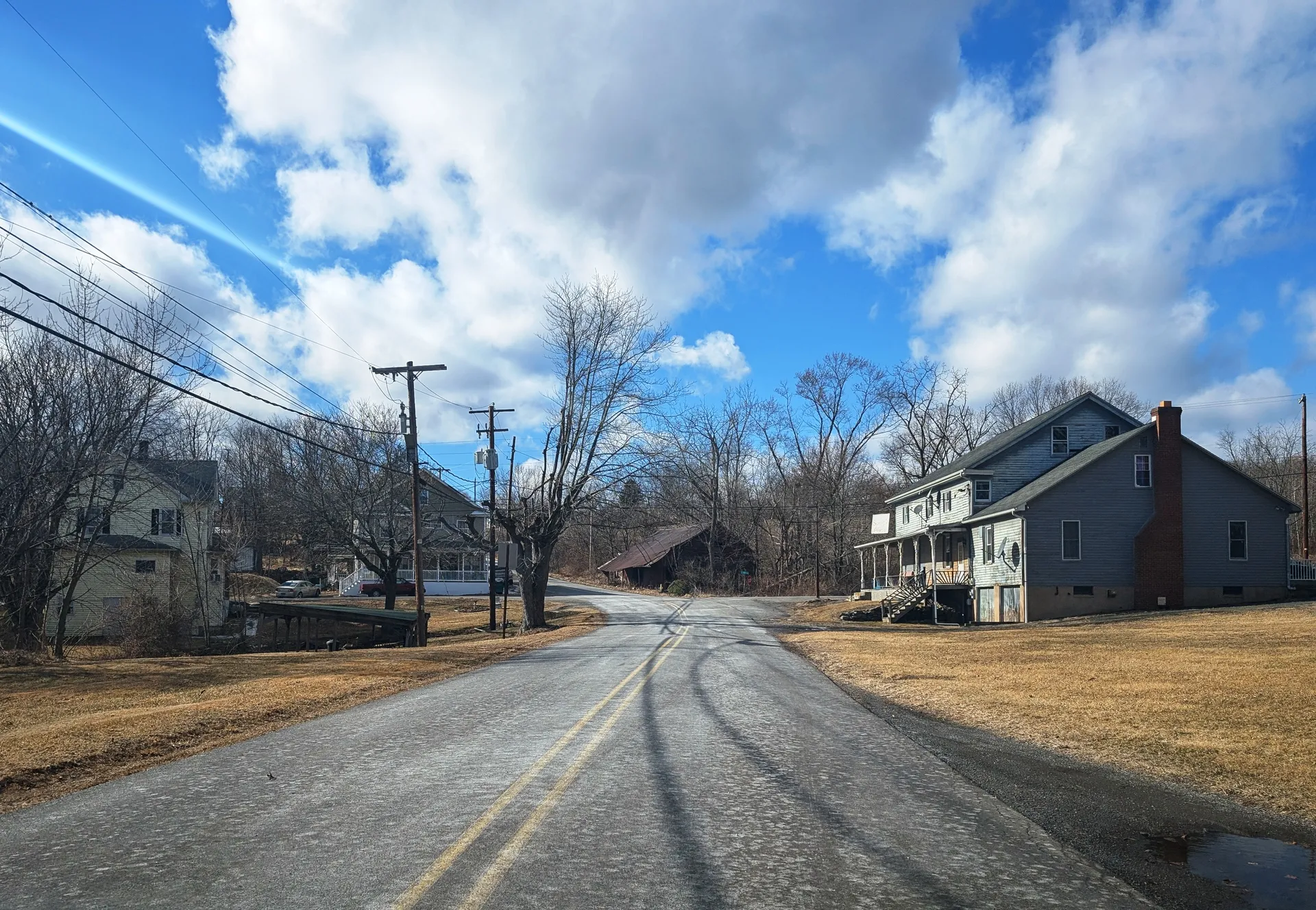 East County Road winds through the tiny village of Hobbie in Hollenback Township, past a gray house and farm fields.