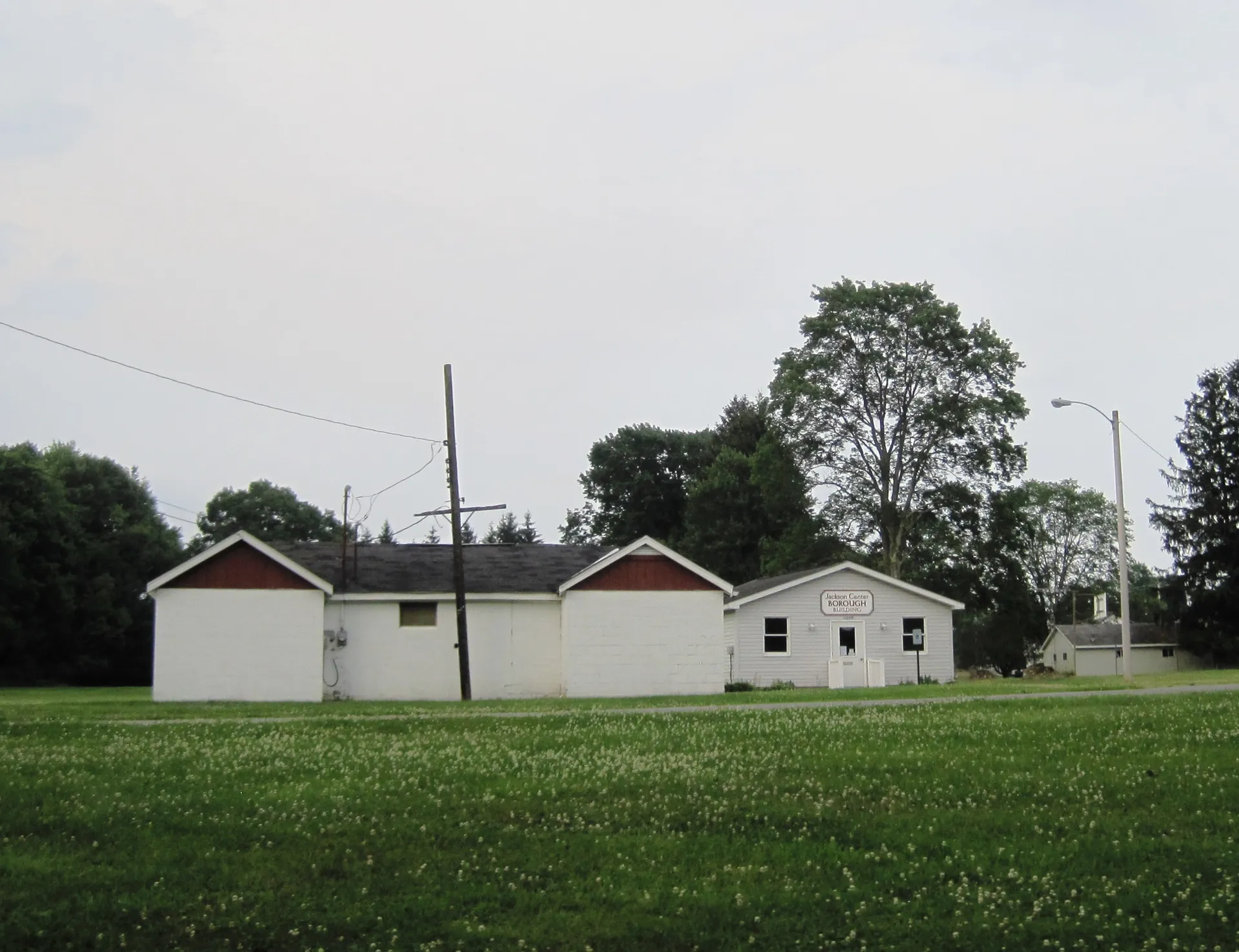 Jackson Center's borough hall is a modest white single-story building set back on a lawn along Clark Street.