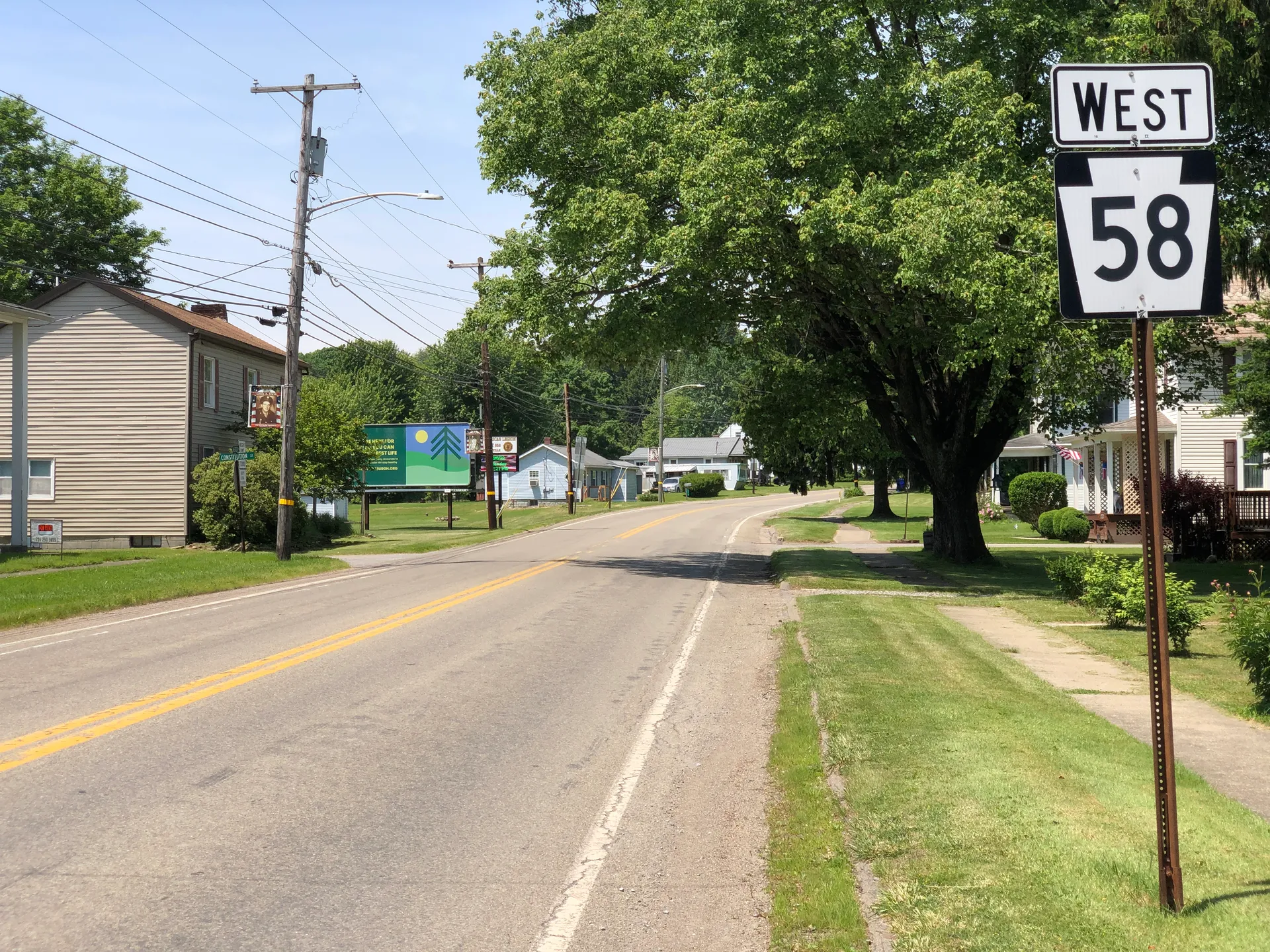 West Mercer Street (Route 58) passes Church Street in Harrisville beneath big maples, with frame houses on both sides.