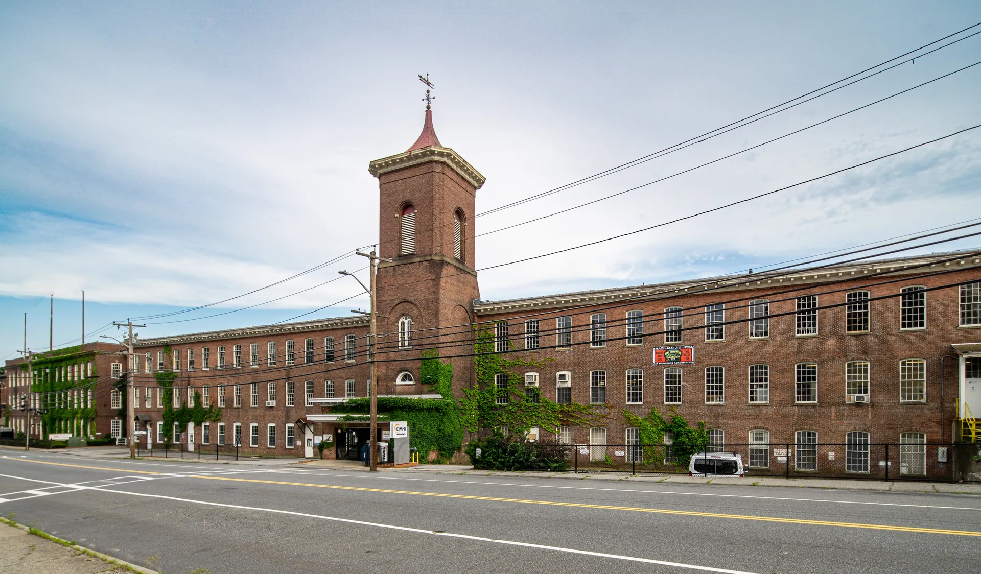 Historic brick Whitin Machine Works mill with clock tower in Whitinsville, Massachusetts.