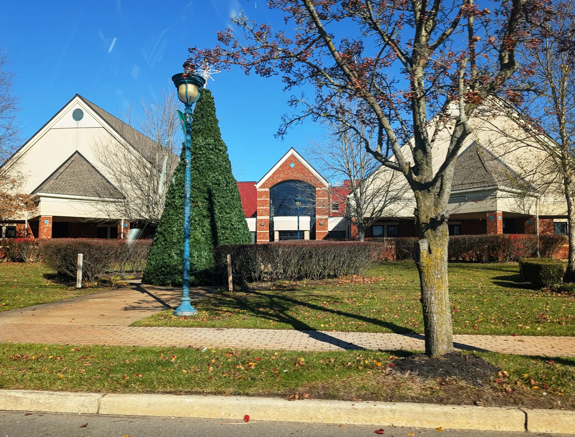 The Stafford Township Municipal Complex in Manahawkin is a brick building seen past a decorated evergreen and lamppost.