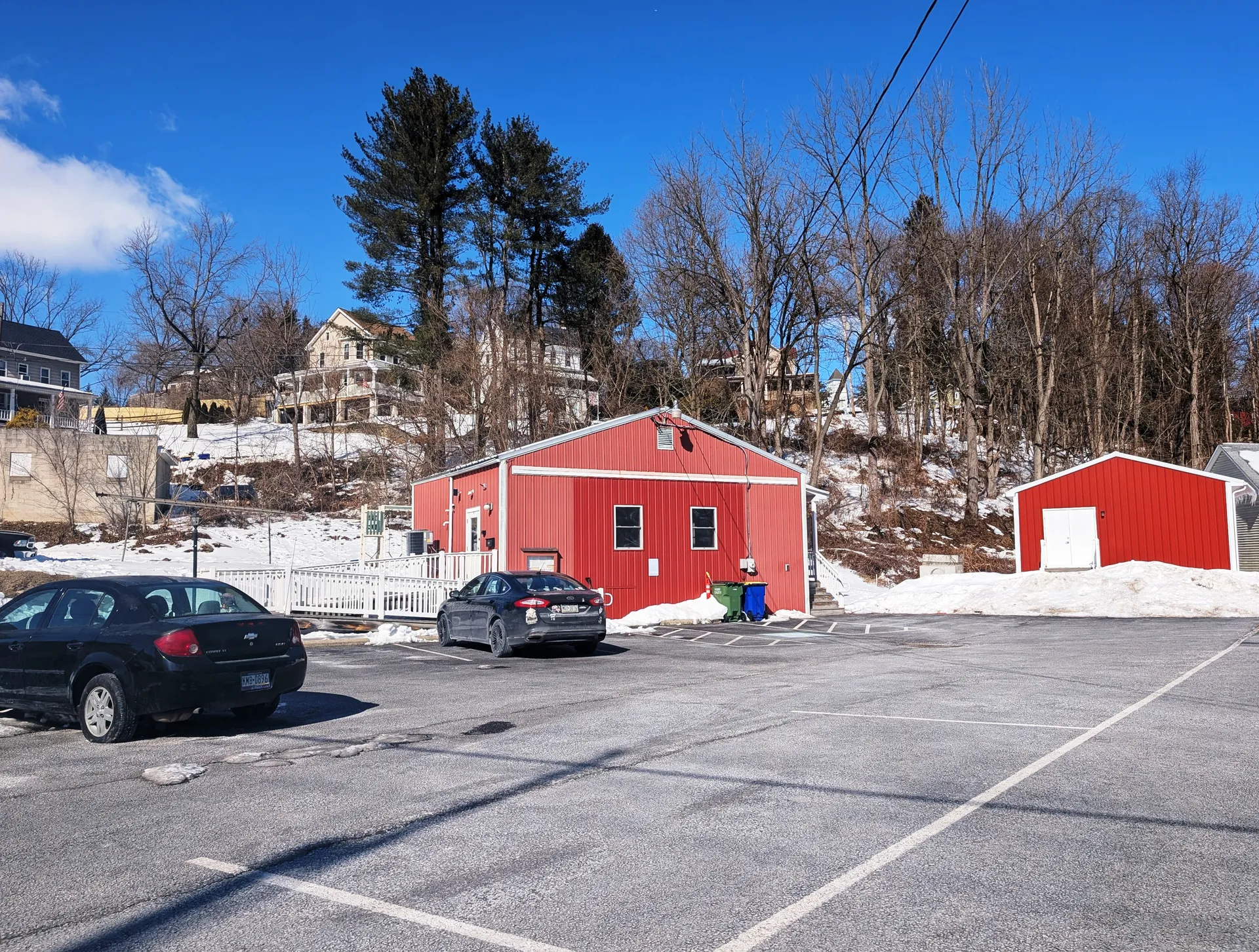 The Felton Borough Office is a red barn-style building beside a snowy wooded hillside and parking lot.