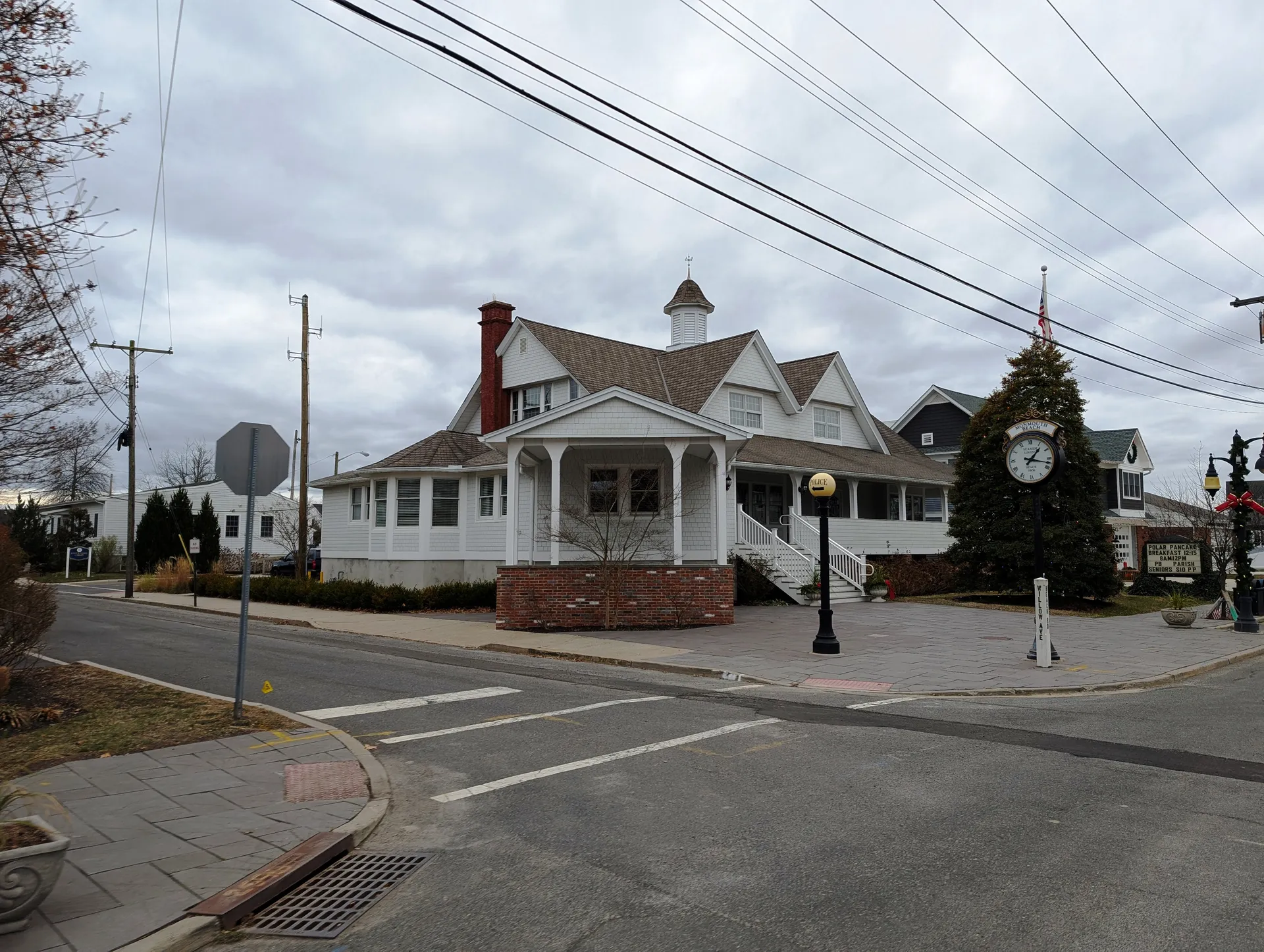Monmouth Beach municipal building is a white Victorian with a wraparound porch and a small cupola on a corner.