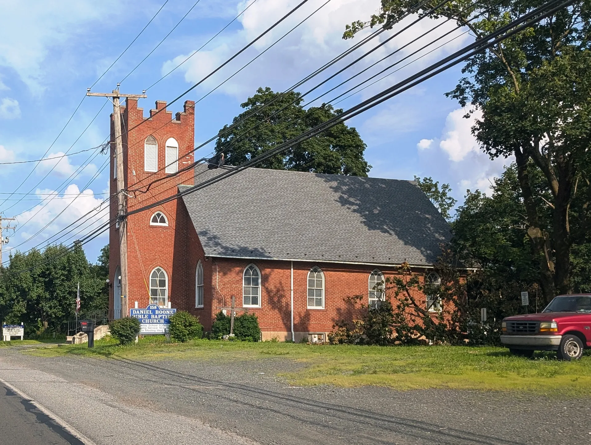 Daniel Boone Bible Baptist Church in Baumstown is a red-brick building with a square bell tower, set behind a mowed lawn along U.S. Route 422.