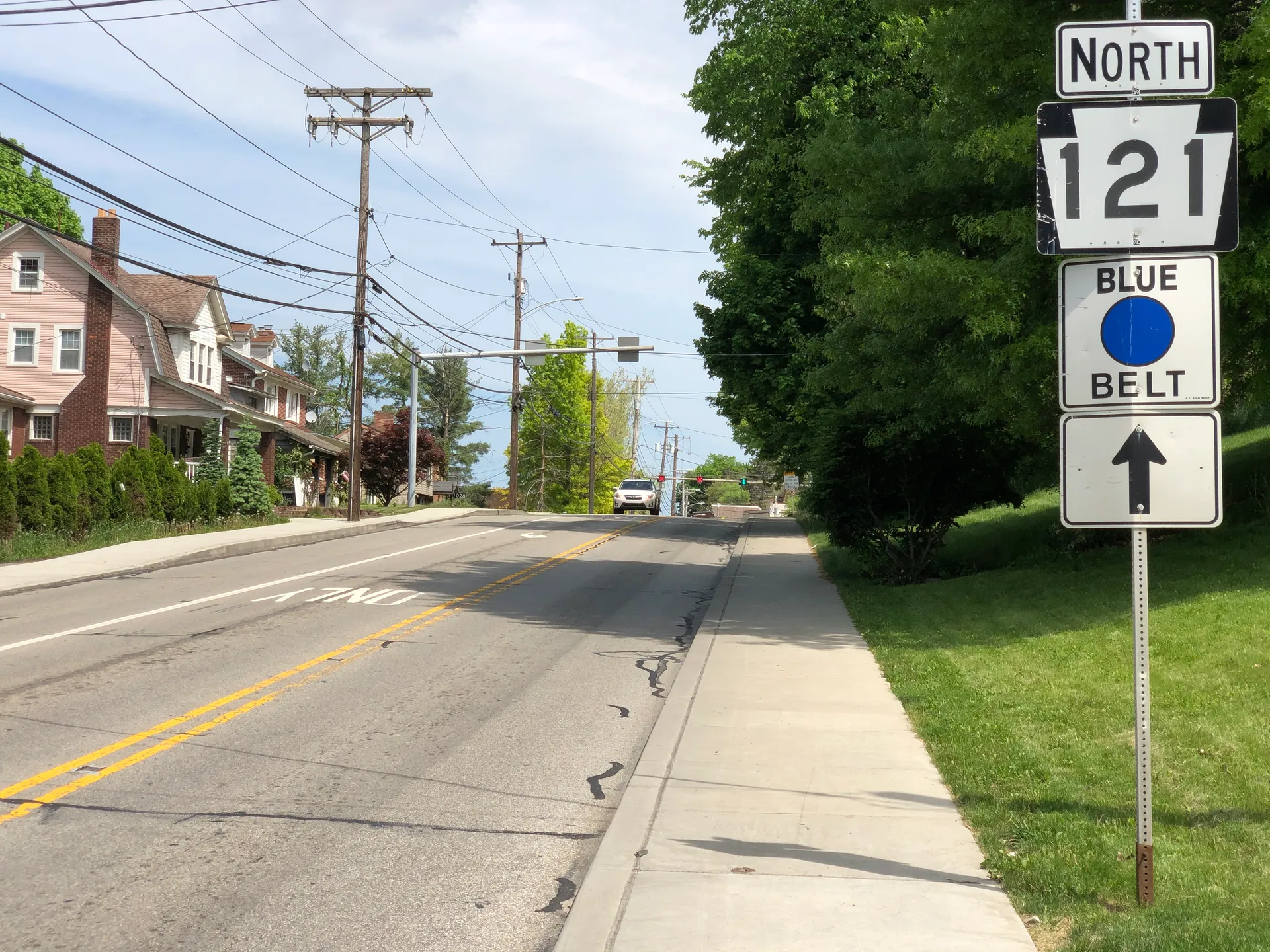 Green Tree Road (Route 121) heads north at Carnahan Road in Green Tree past sidewalks, homes and utility poles.