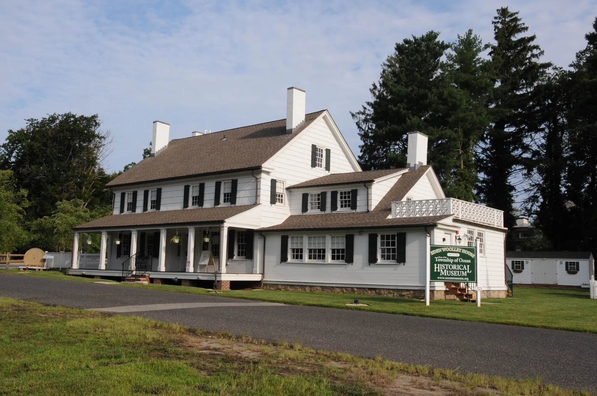 The Township of Ocean Historical Museum in Oakhurst is a white two-story house with green shutters and a porch.