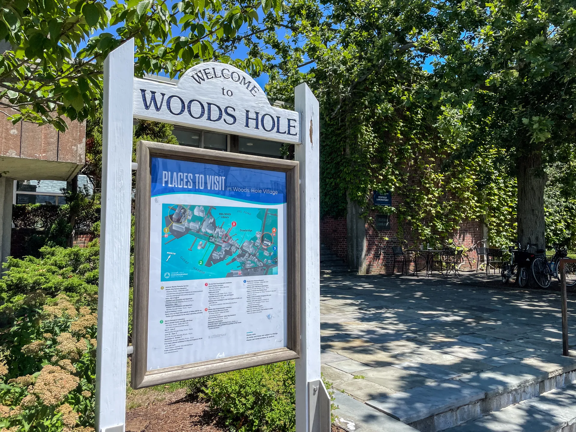 Welcome to Woods Hole sign on a tree-lined street in Woods Hole, Massachusetts.