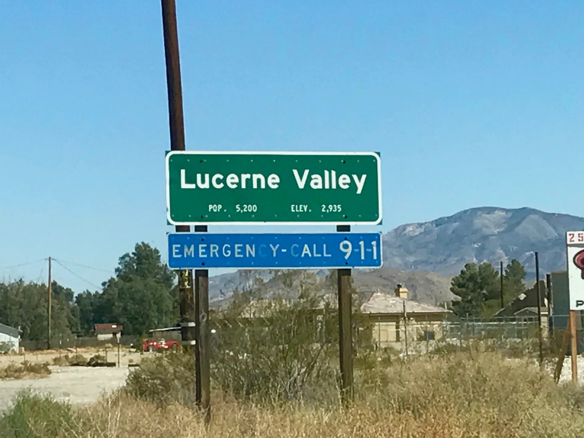 A Lucerne Valley welcome sign with mountains in the background in California.