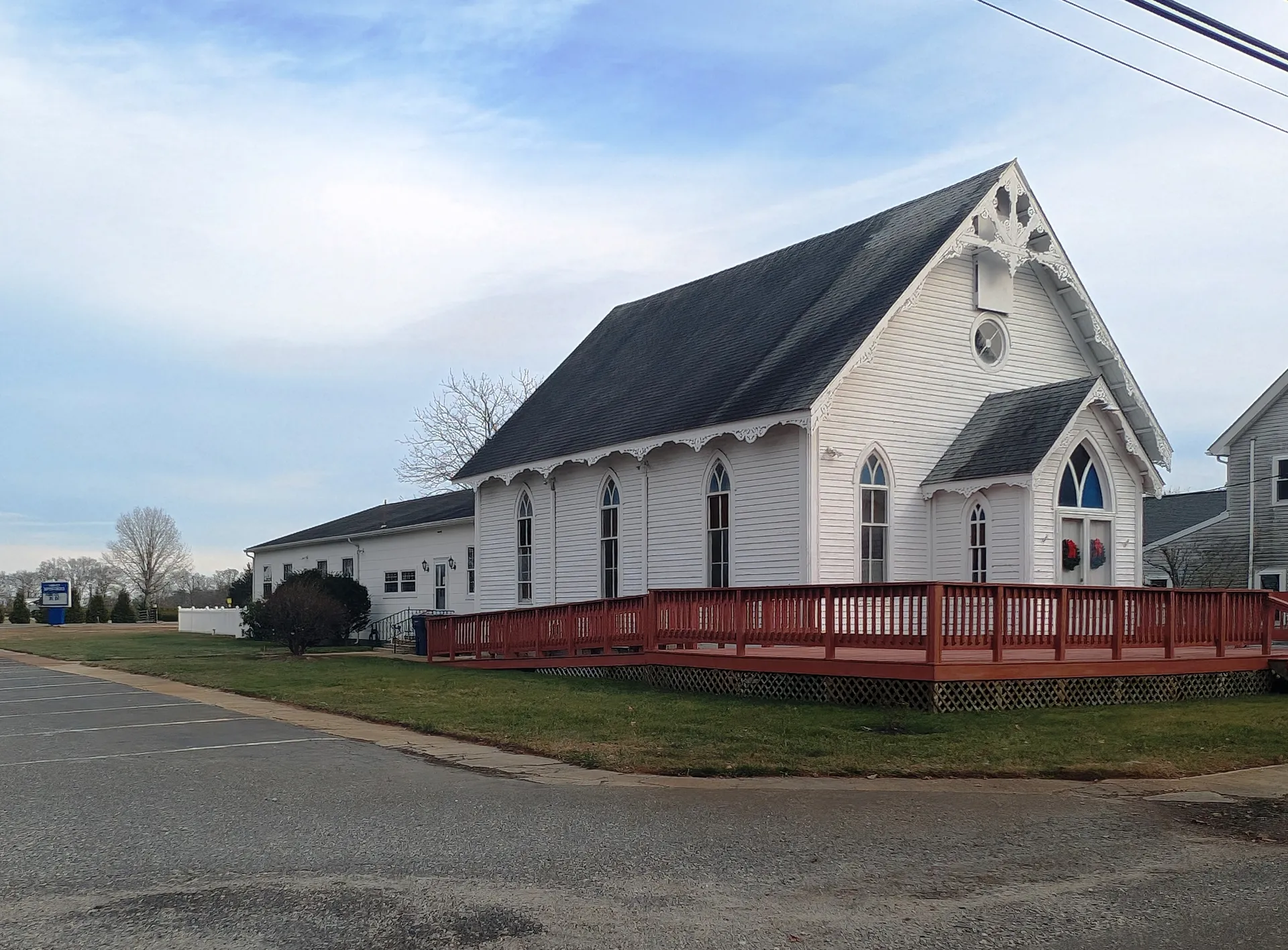 Corbin City Baptist Church is a white church with a steep gable and pointed windows, fronted by a red-railed deck.