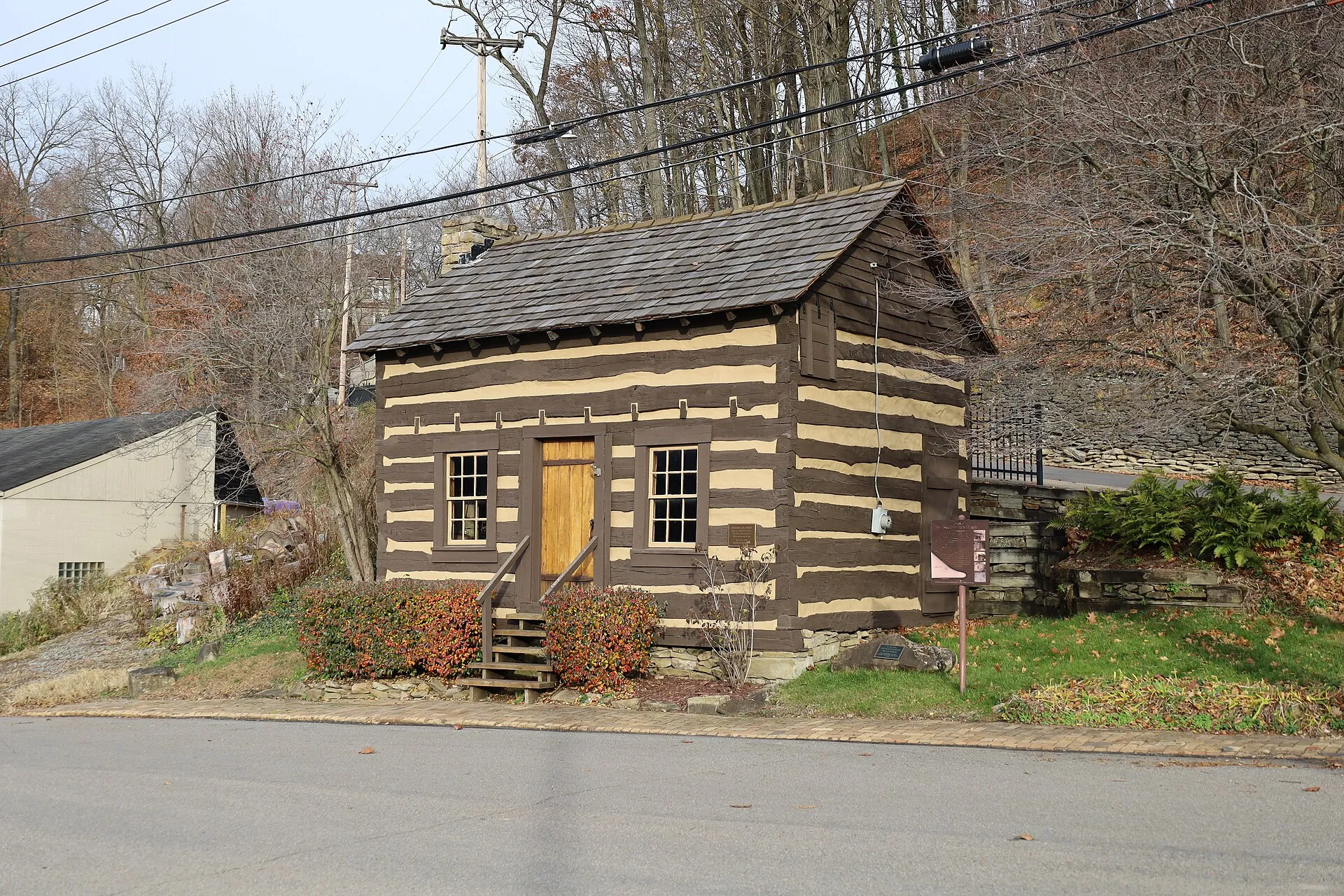 The Dickson Log House in Ben Avon is a historic two-story log dwelling with chinked walls, a shingled roof and stone steps.